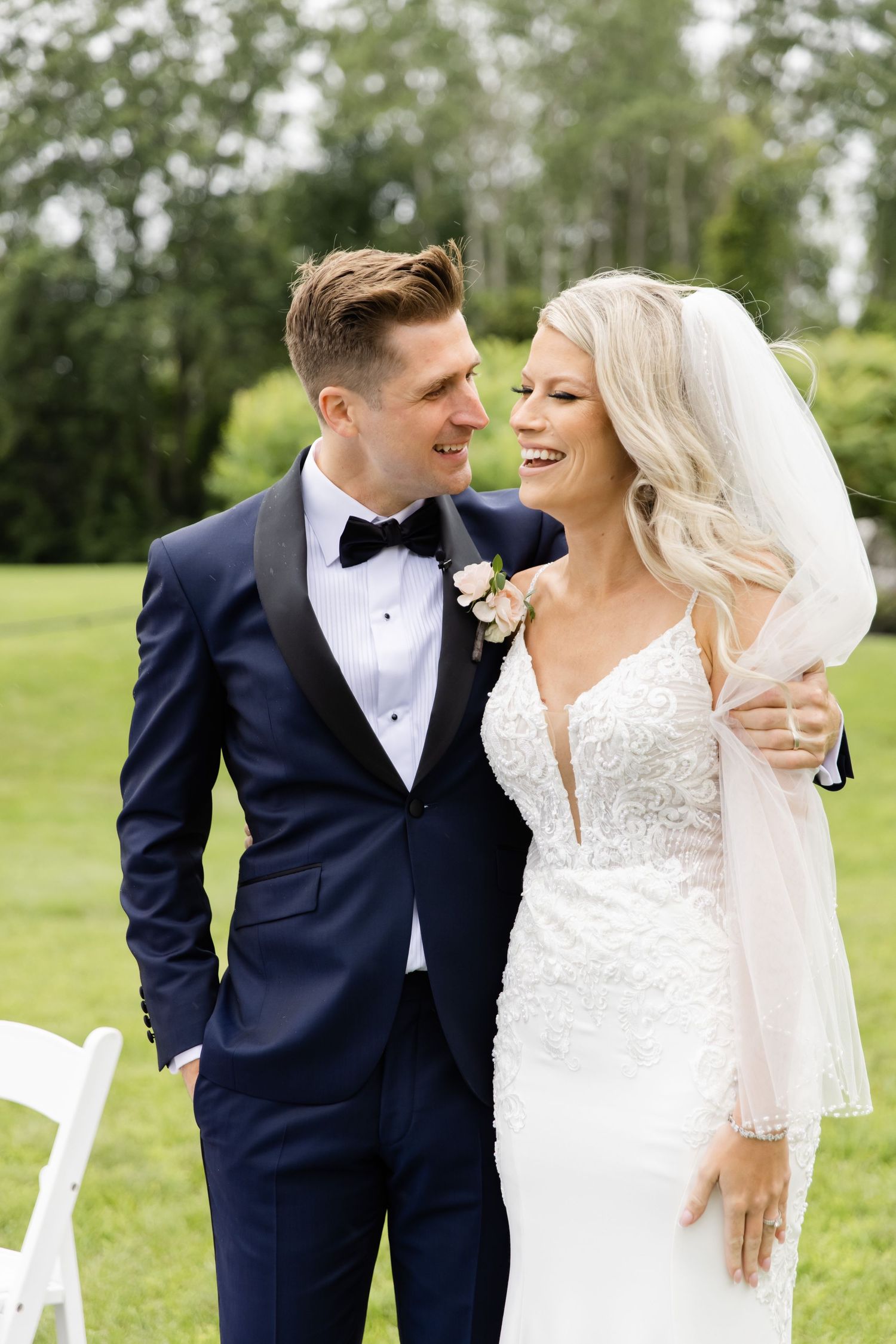 Elegant couple shares romantic moment outdoors in formal wedding attire.