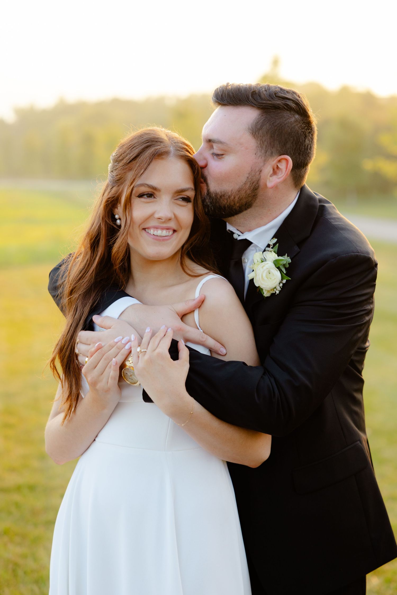 Wedding couple shares an affectionate moment during sunset portrait session outdoors.