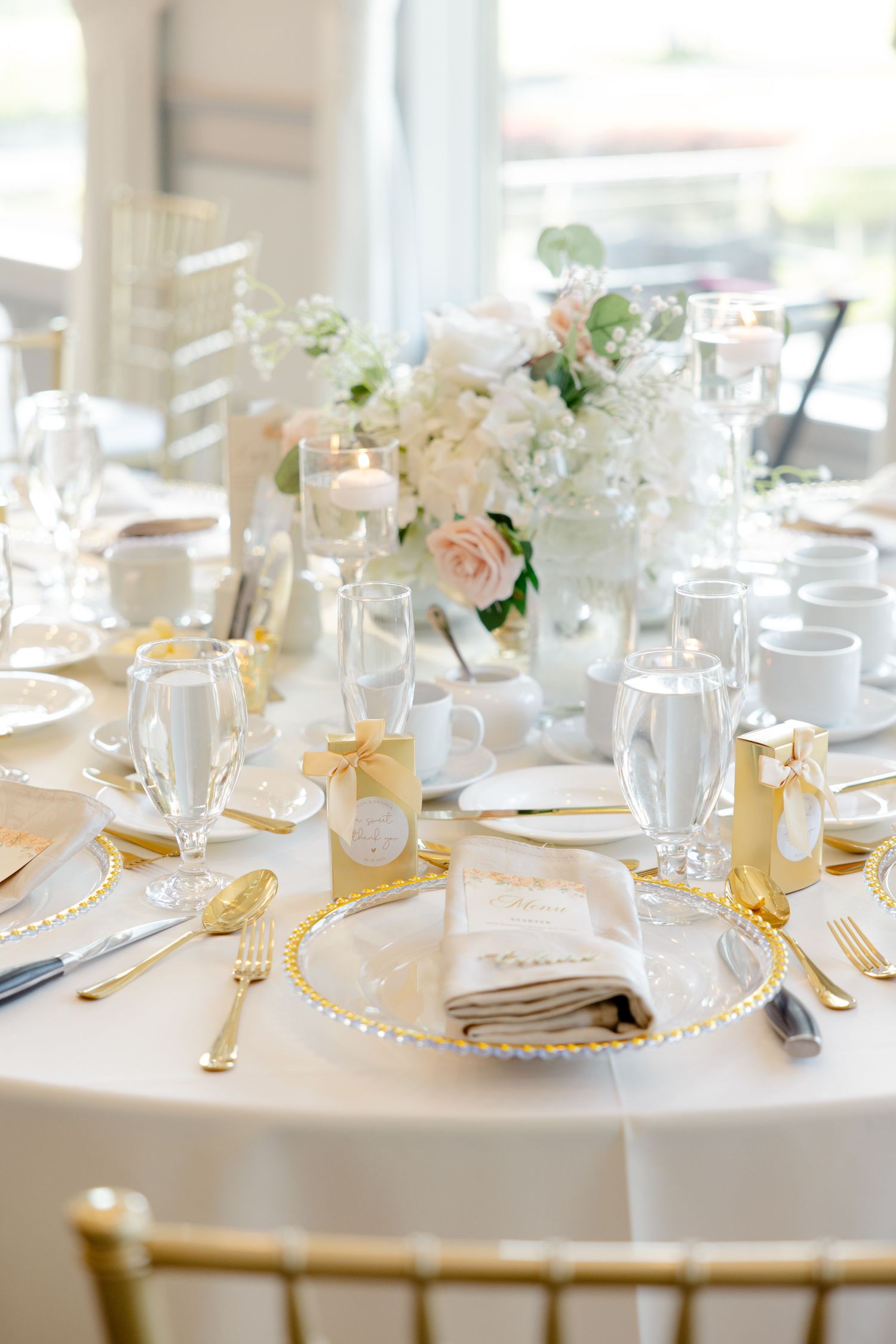 Champagne tower setup on white tablecloth with floral decor.