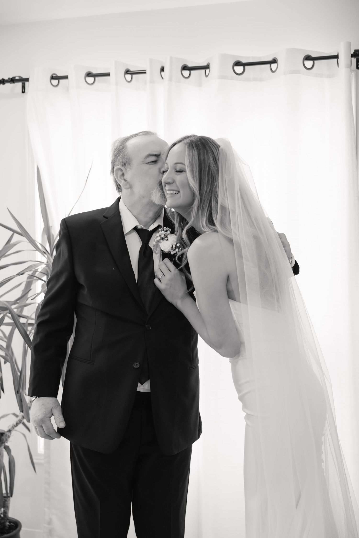 Sweet embrace between bride in white dress and man in suit during wedding ceremony.