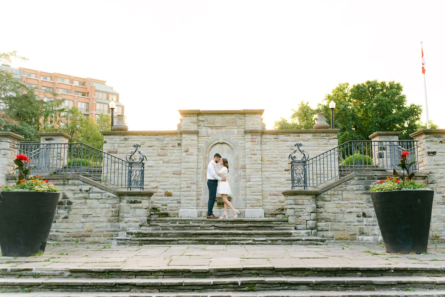 Couple standing on grand stone staircase during golden hour.