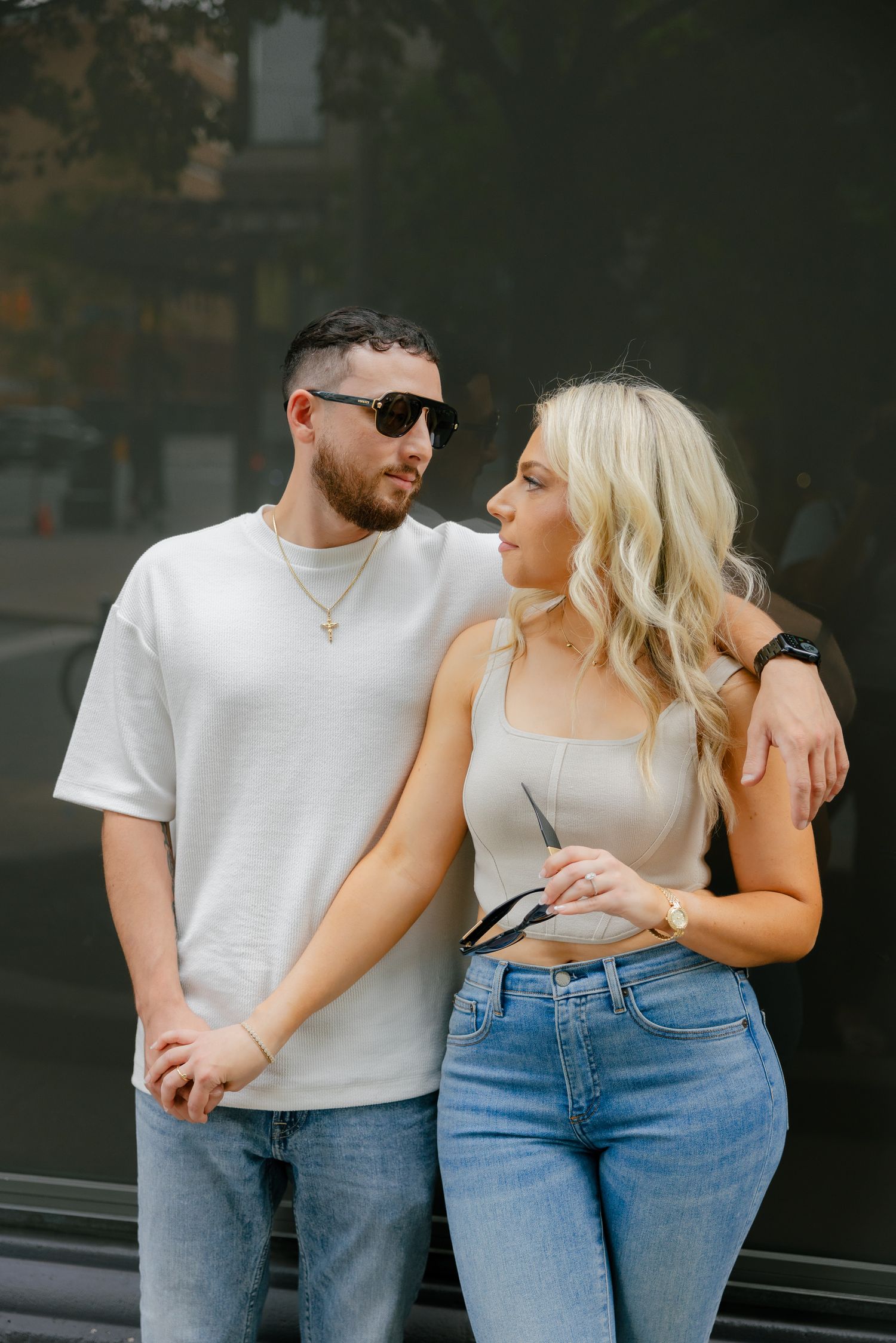 Stylish streetwear couple sharing intimate moment against dark city backdrop.