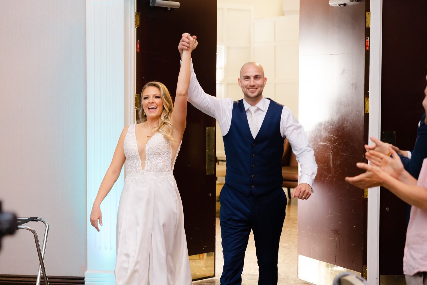 Grand entrance into wedding reception with celebratory pose.