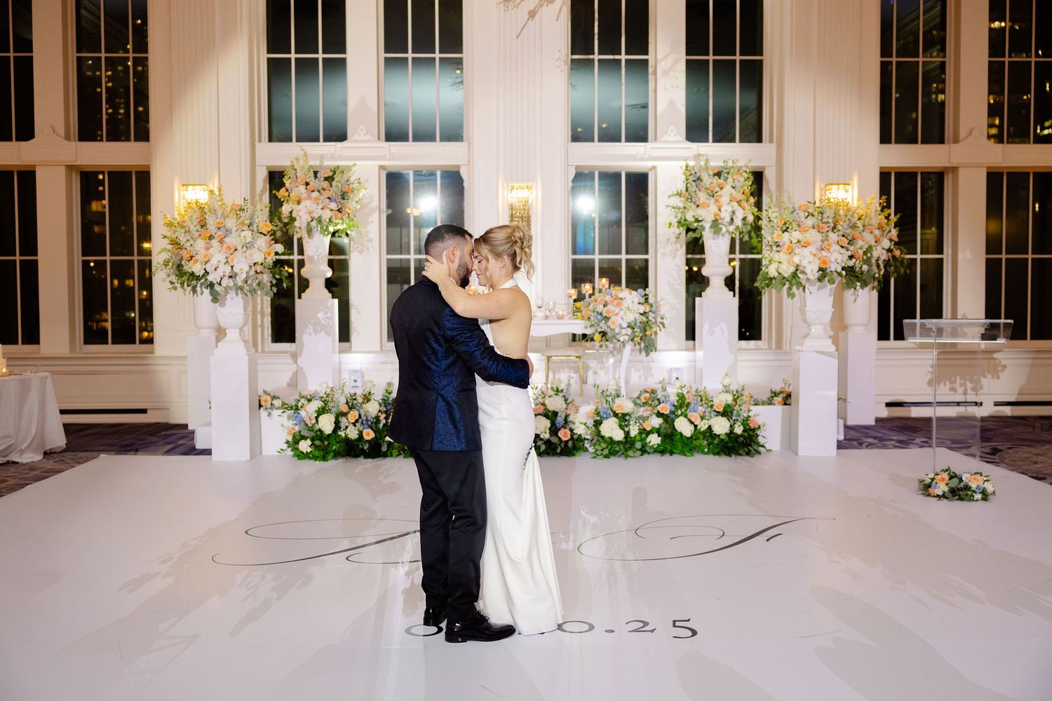 Elegant wedding venue interior with large windows and floral decorations.