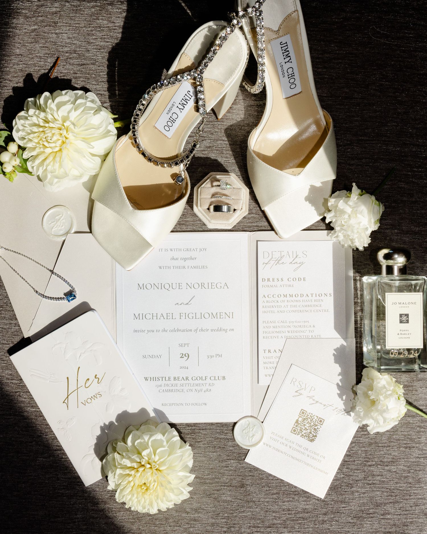 Wedding stationery flat lay with ivory heels, Jo Malone perfume and white dahlia flowers.