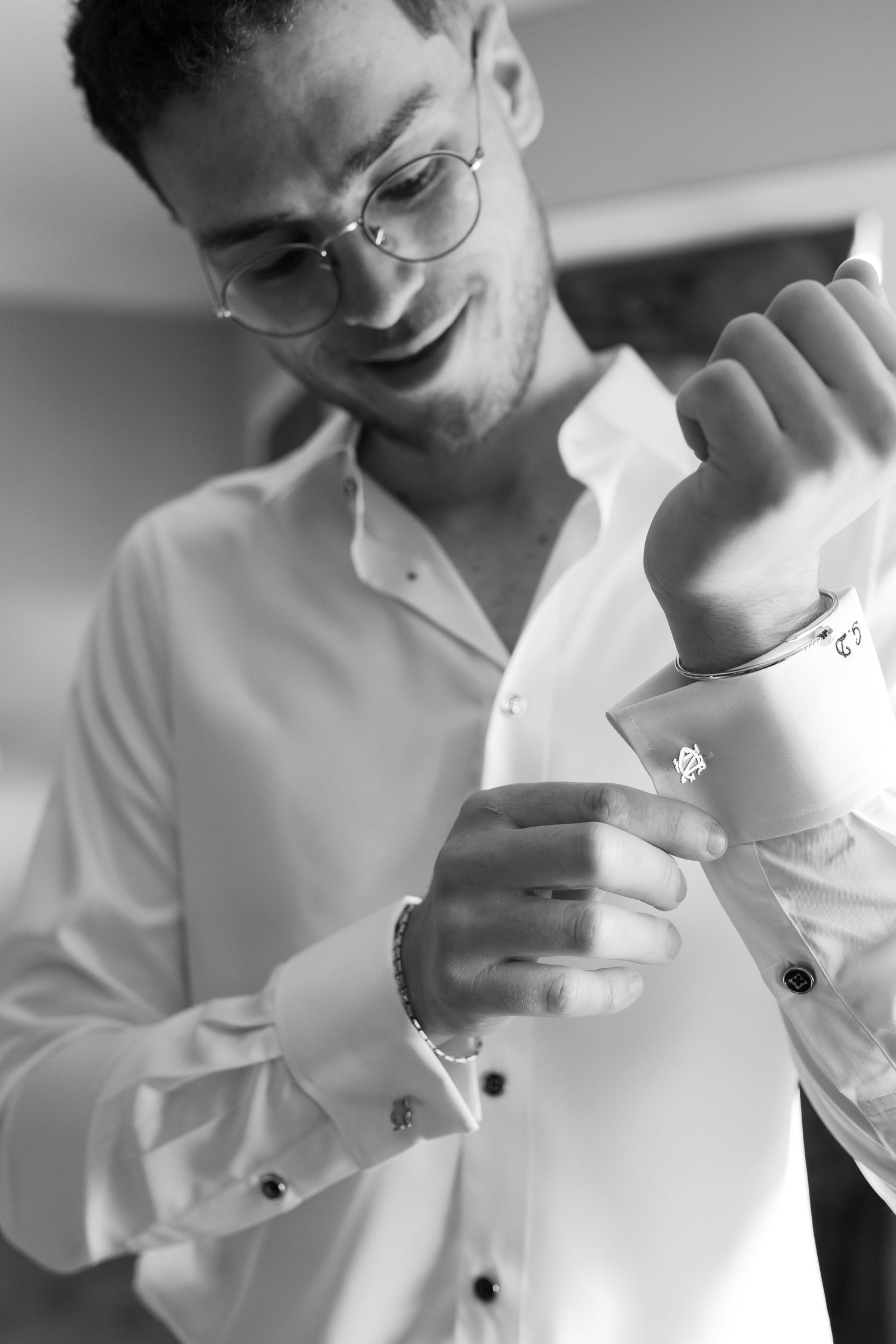 Black and white photo of someone adjusting their dress shirt cuff.