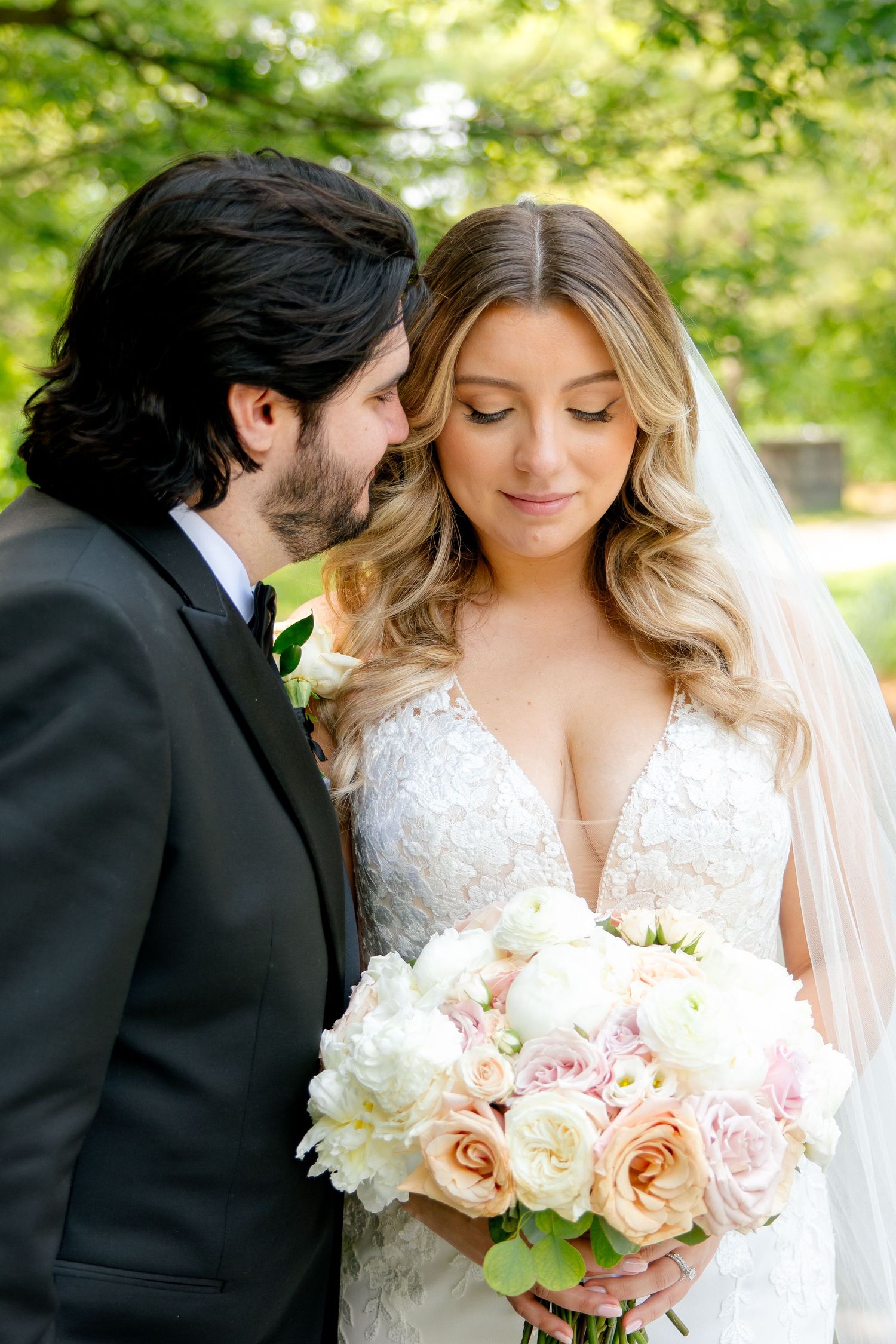 A tender wedding portrait featuring a beautiful bouquet of pink and white roses.