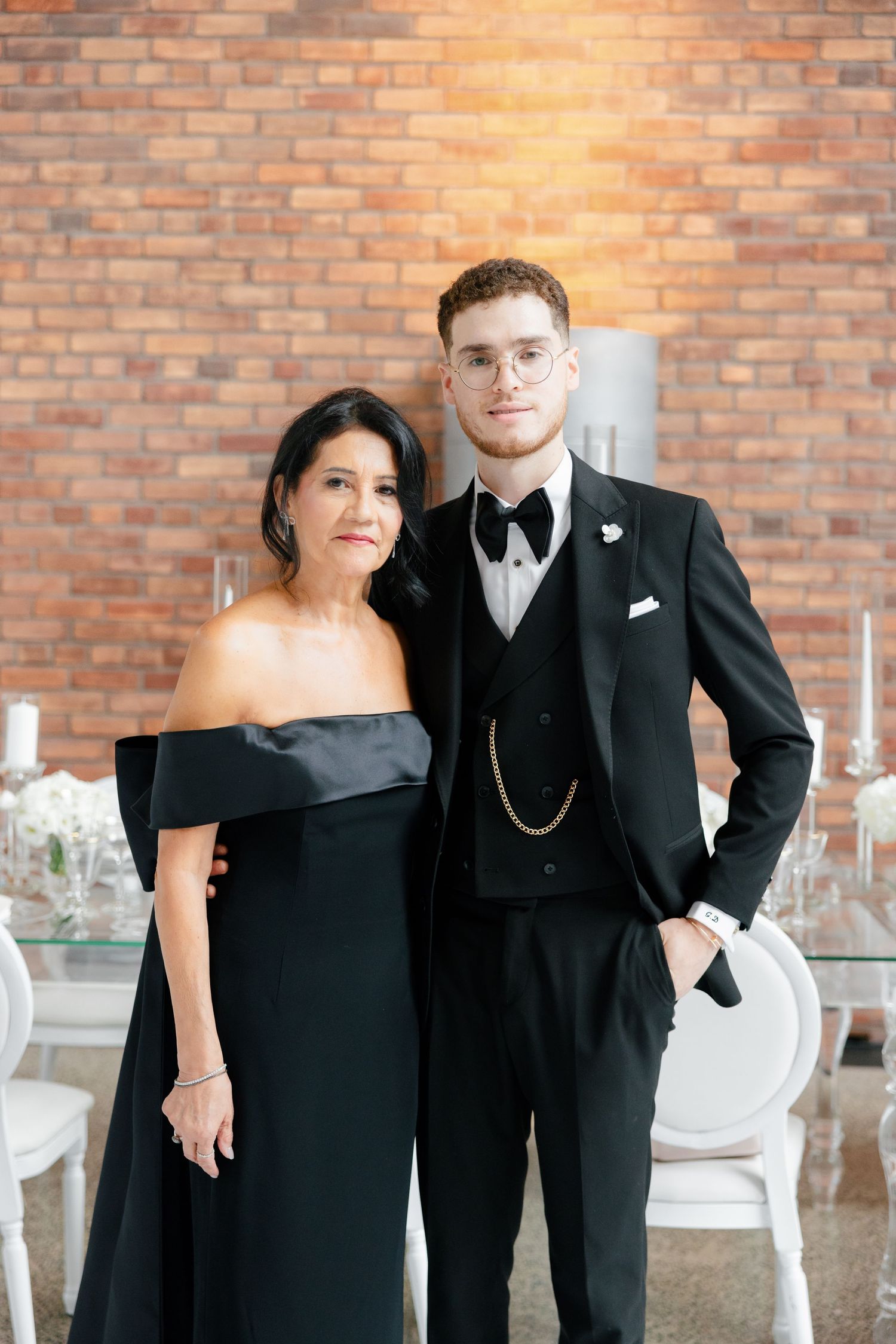Elegant formal portrait against brick wall at modern wedding reception venue.
