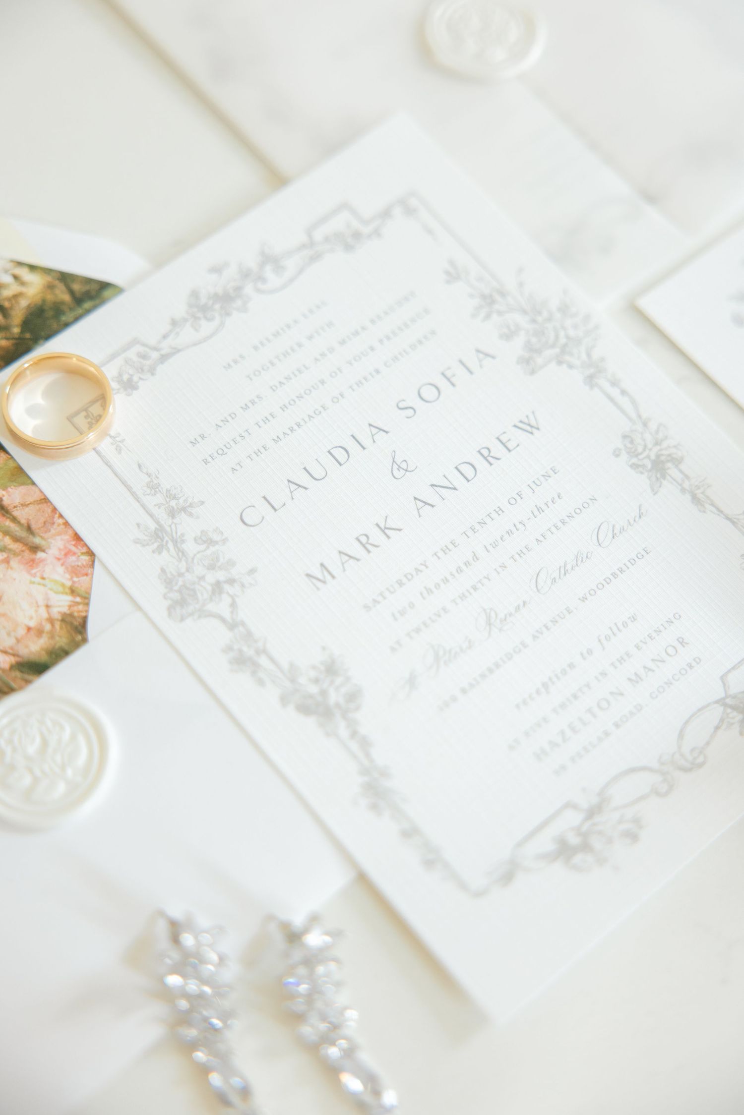 Elegant wedding invitation with delicate gray floral border design and text on white paper.