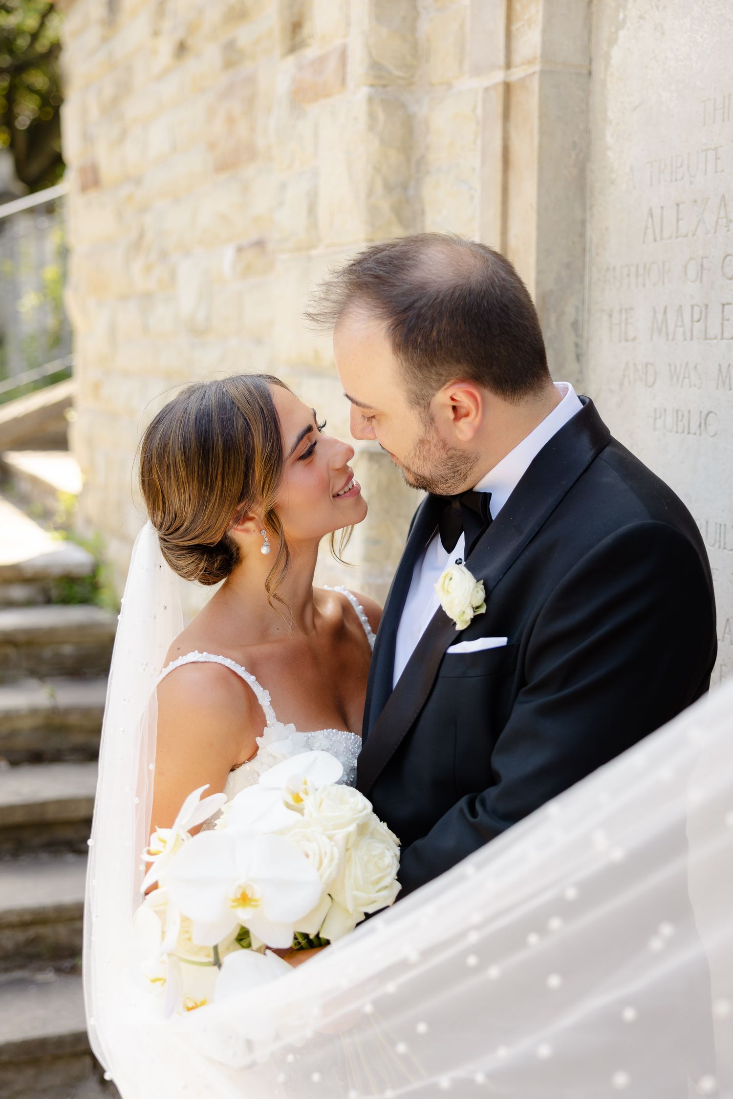 A series of intimate wedding photos showing tender moments between a couple against a light stone wall background.