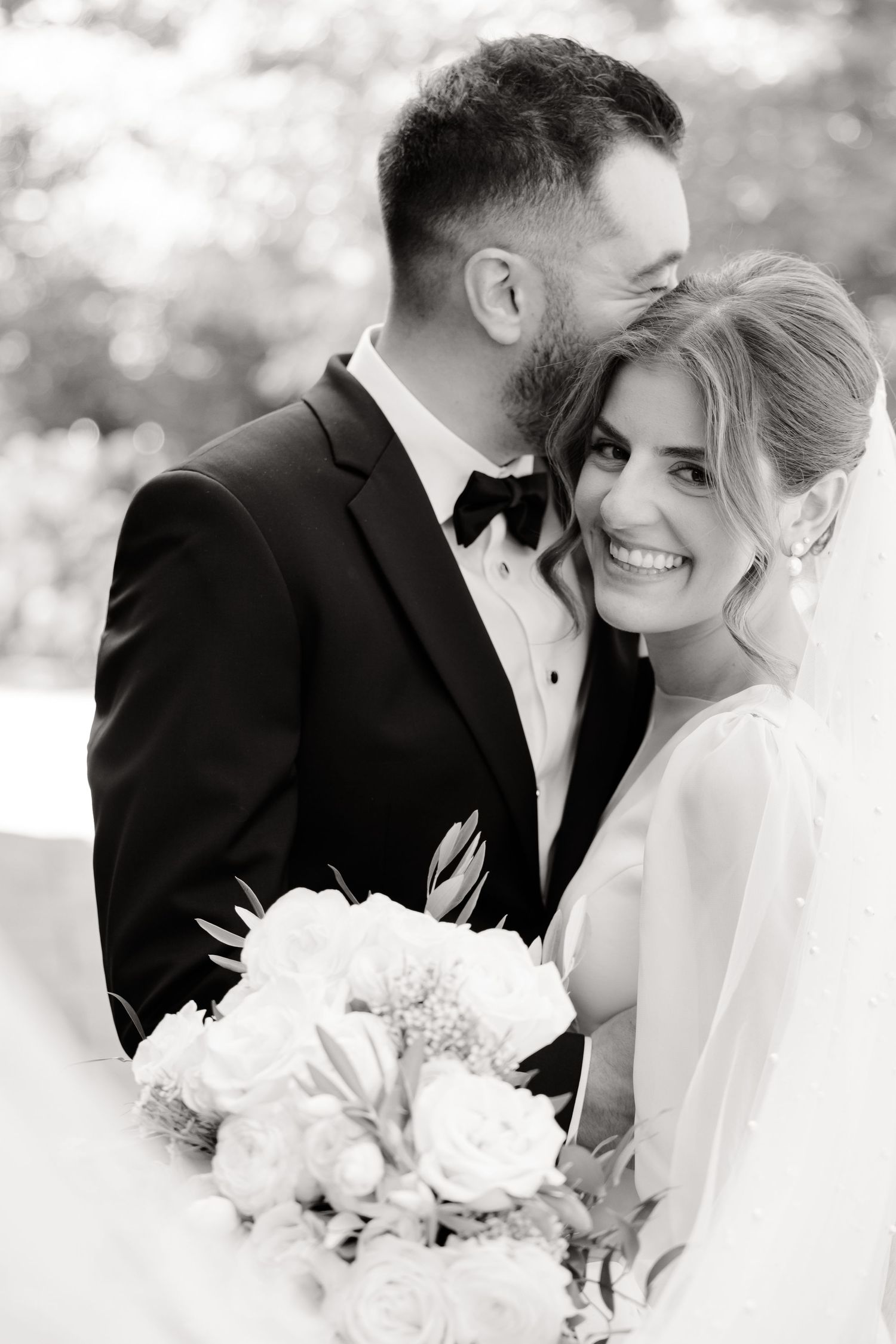 Black and white portrait of happy newlyweds sharing an intimate moment.