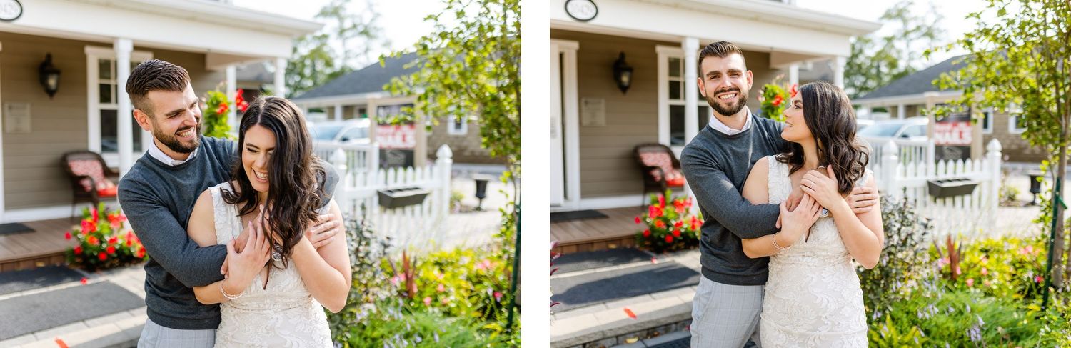 A couple laughs together while standing on their front porch surrounded by flowers.
