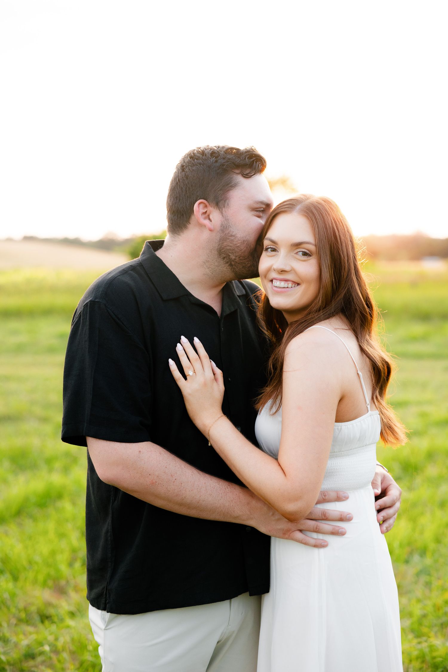 A candid moment between a couple embracing during their golden hour engagement shoot.