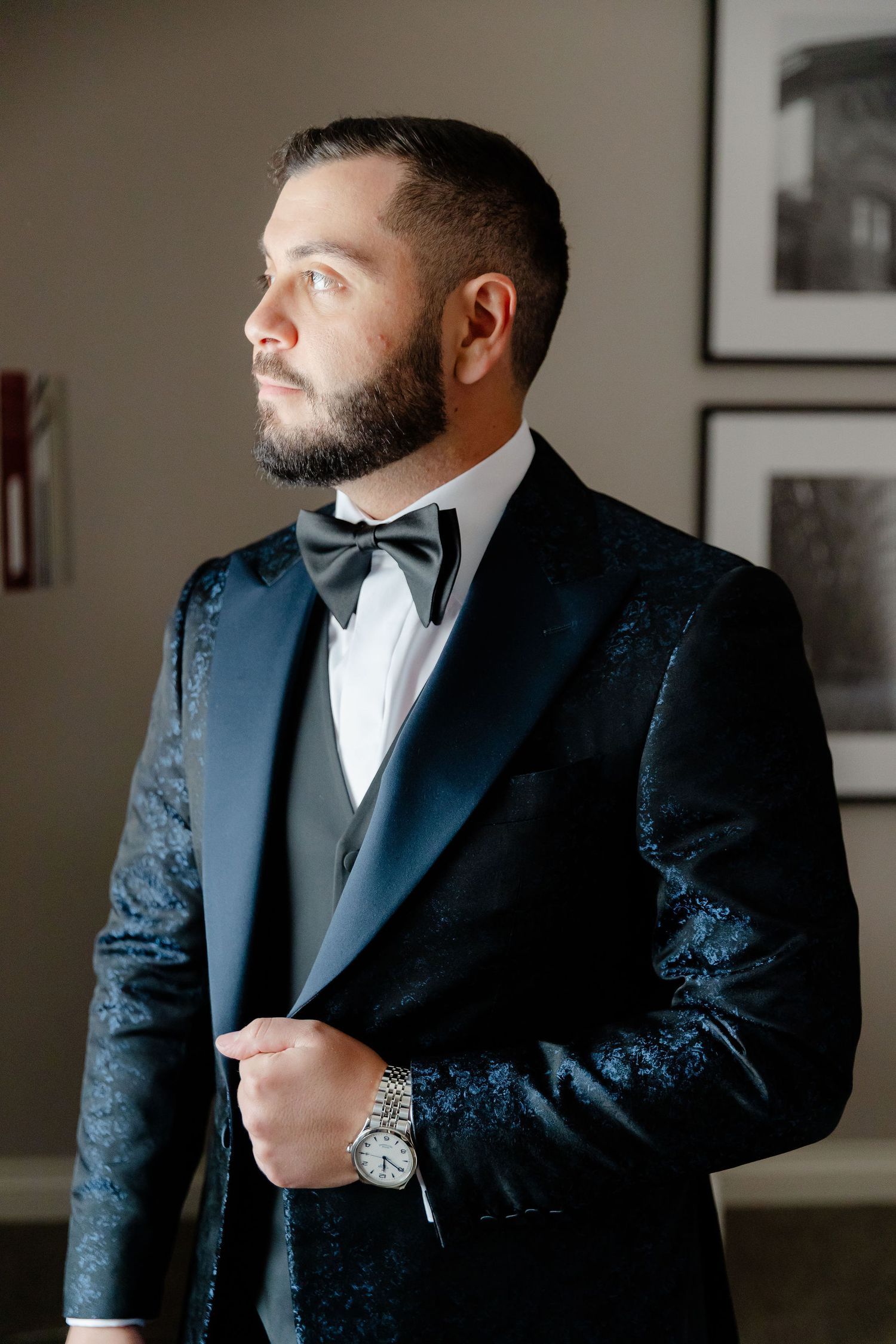 Formal wedding attire featuring a textured navy tuxedo jacket with black lapels.