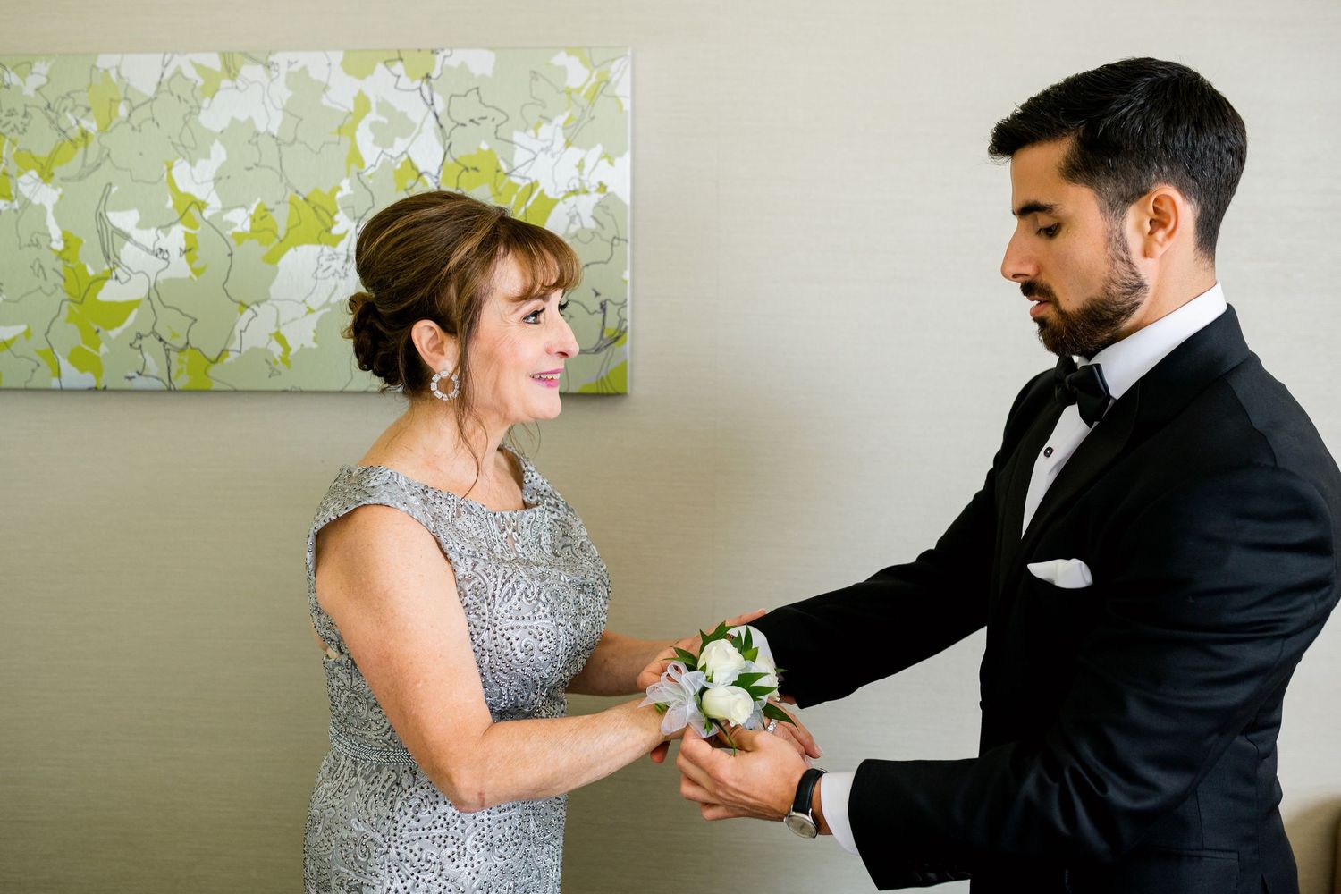 A touching moment as corsage is exchanged between two people in formal attire.