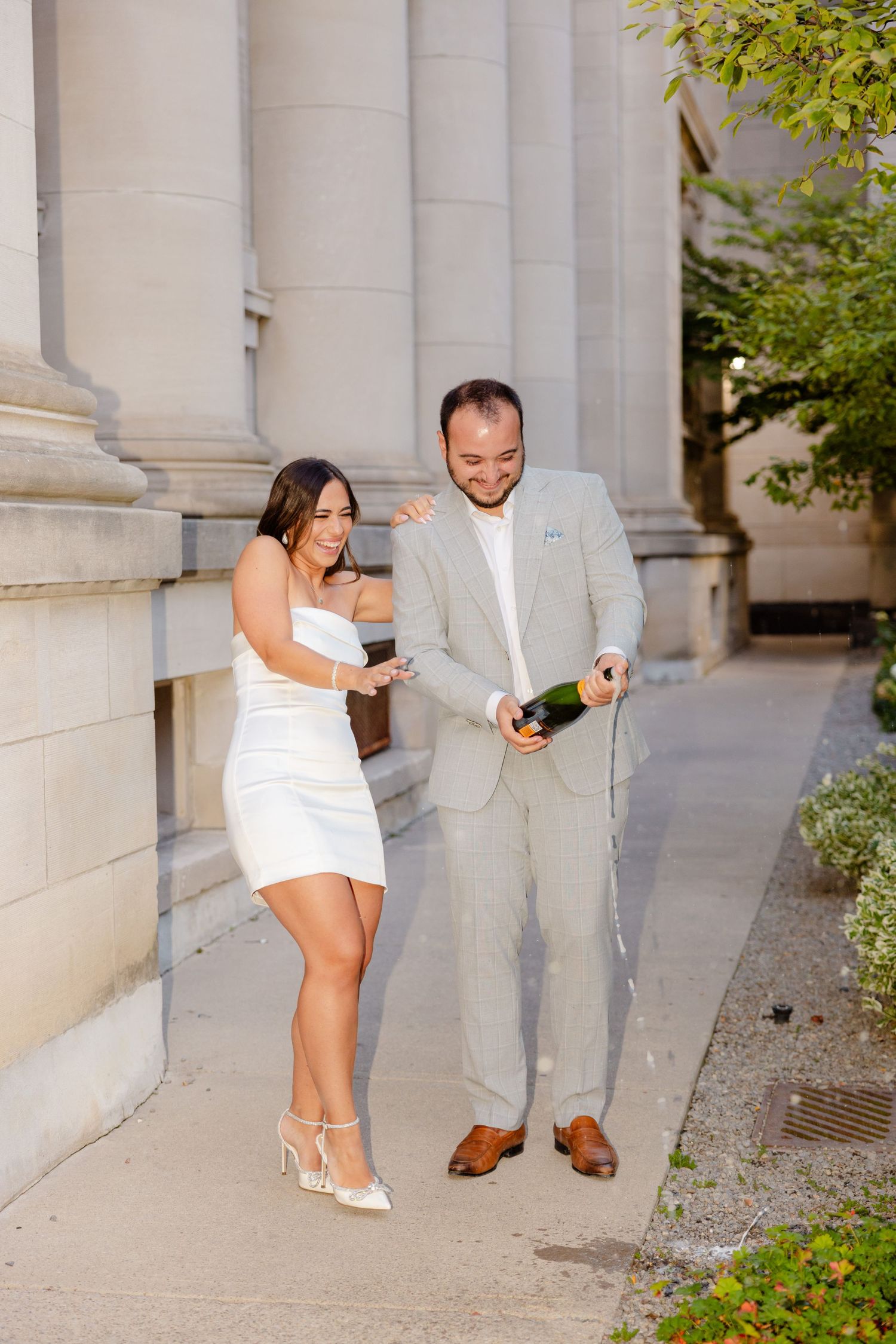 Fun champagne celebration moment captured by classical architecture.