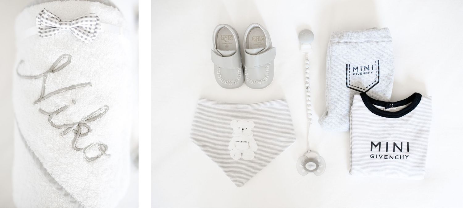 Baby accessories including bib, shoes, and clothing in neutral gray and white colors.