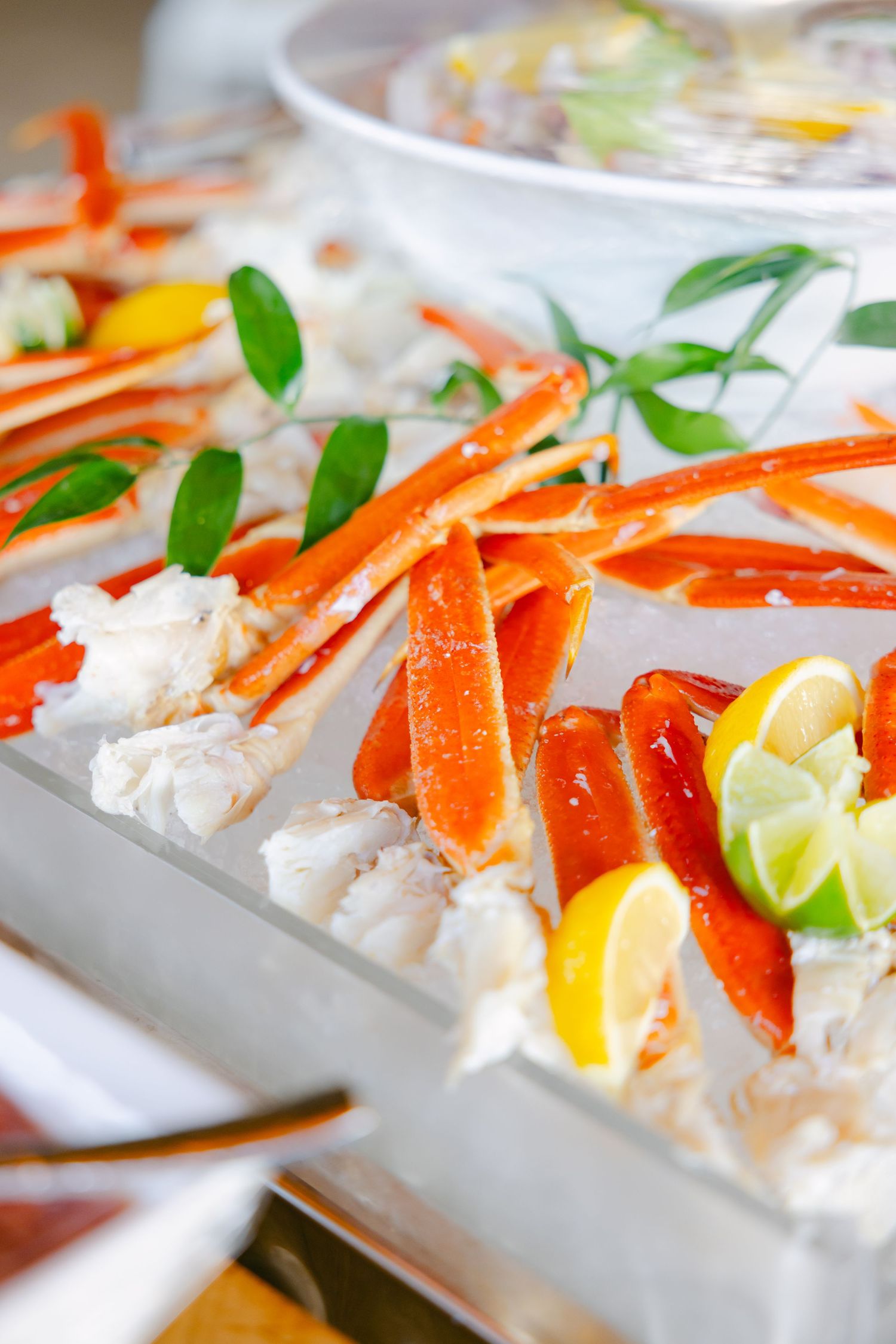 Fresh seafood and crab legs displayed on ice with citrus garnishes and greenery.