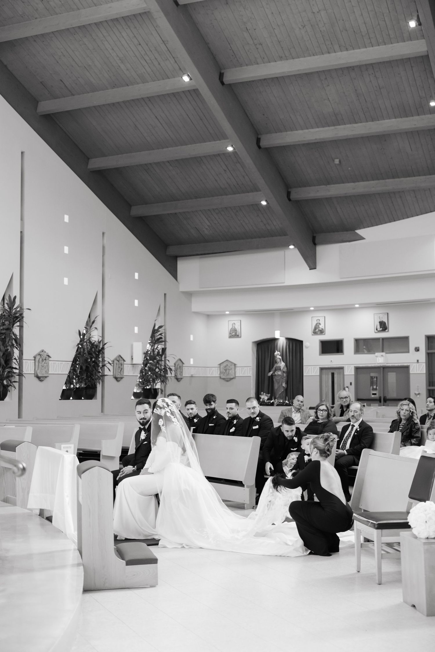 Black and white photo of a wedding ceremony in a modern church interior.