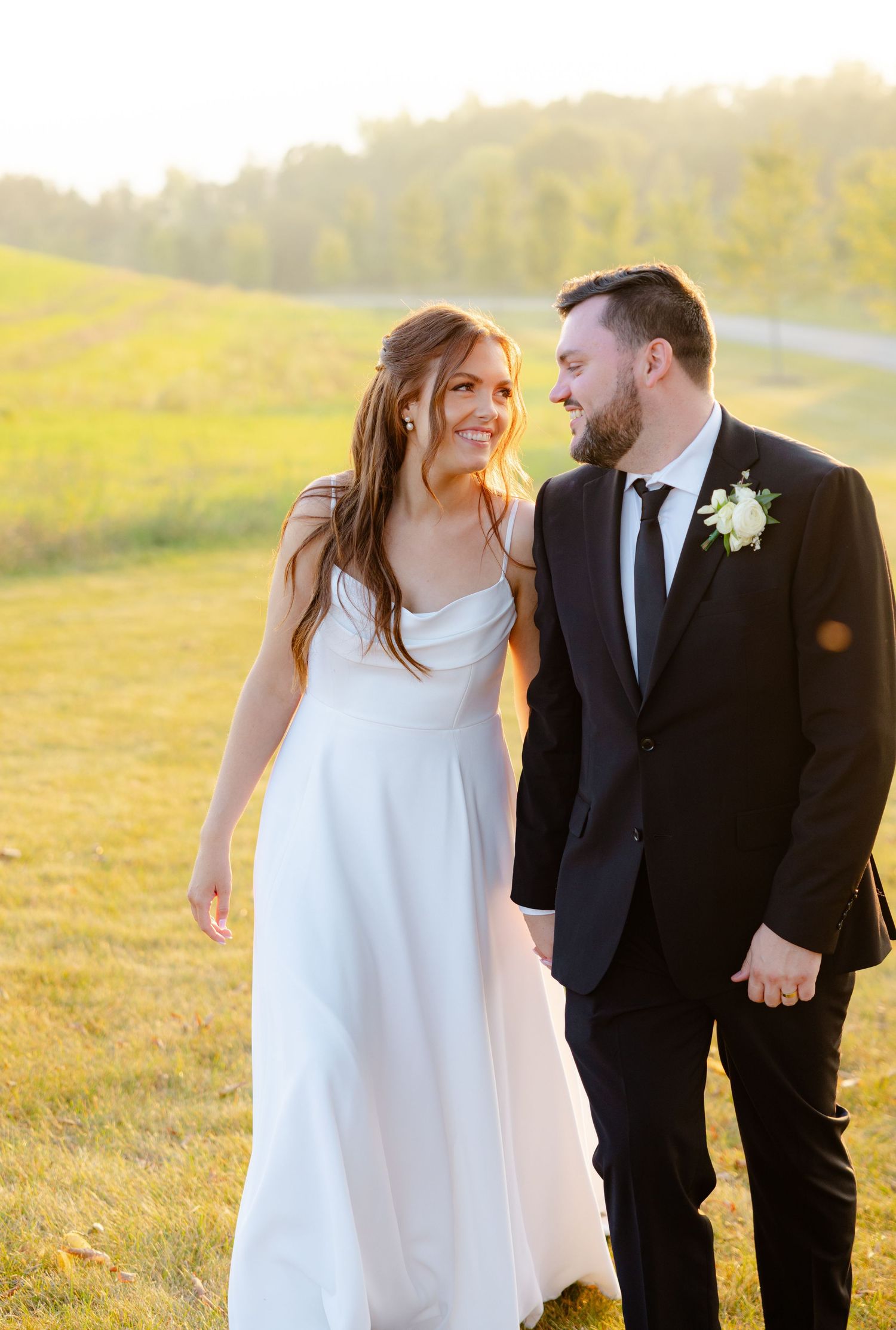 A couple shares a candid moment of laughter during their sunset wedding photoshoot.