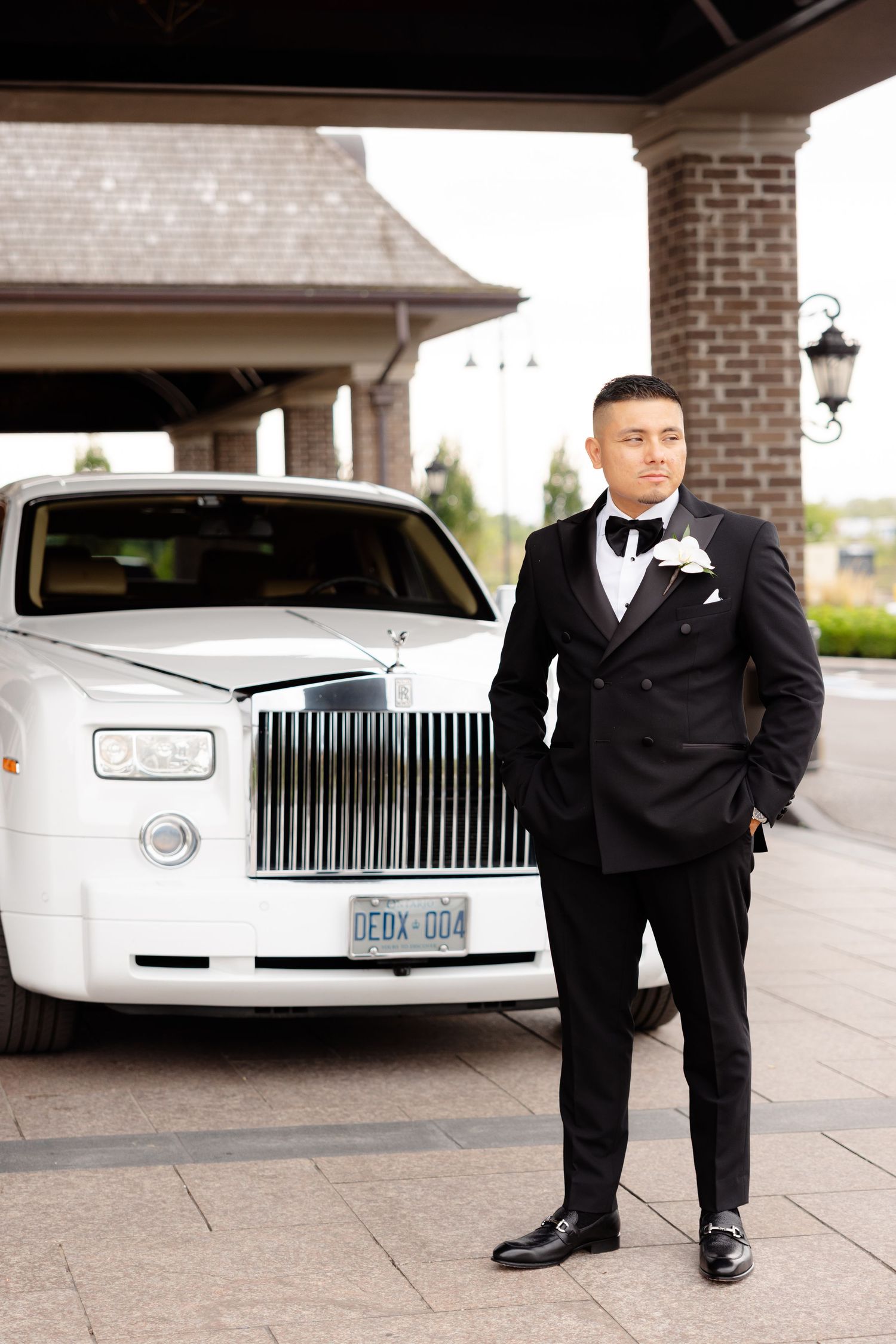 A series of wedding portrait shots featuring black tuxedos and a white Rolls-Royce luxury car at a brick venue.