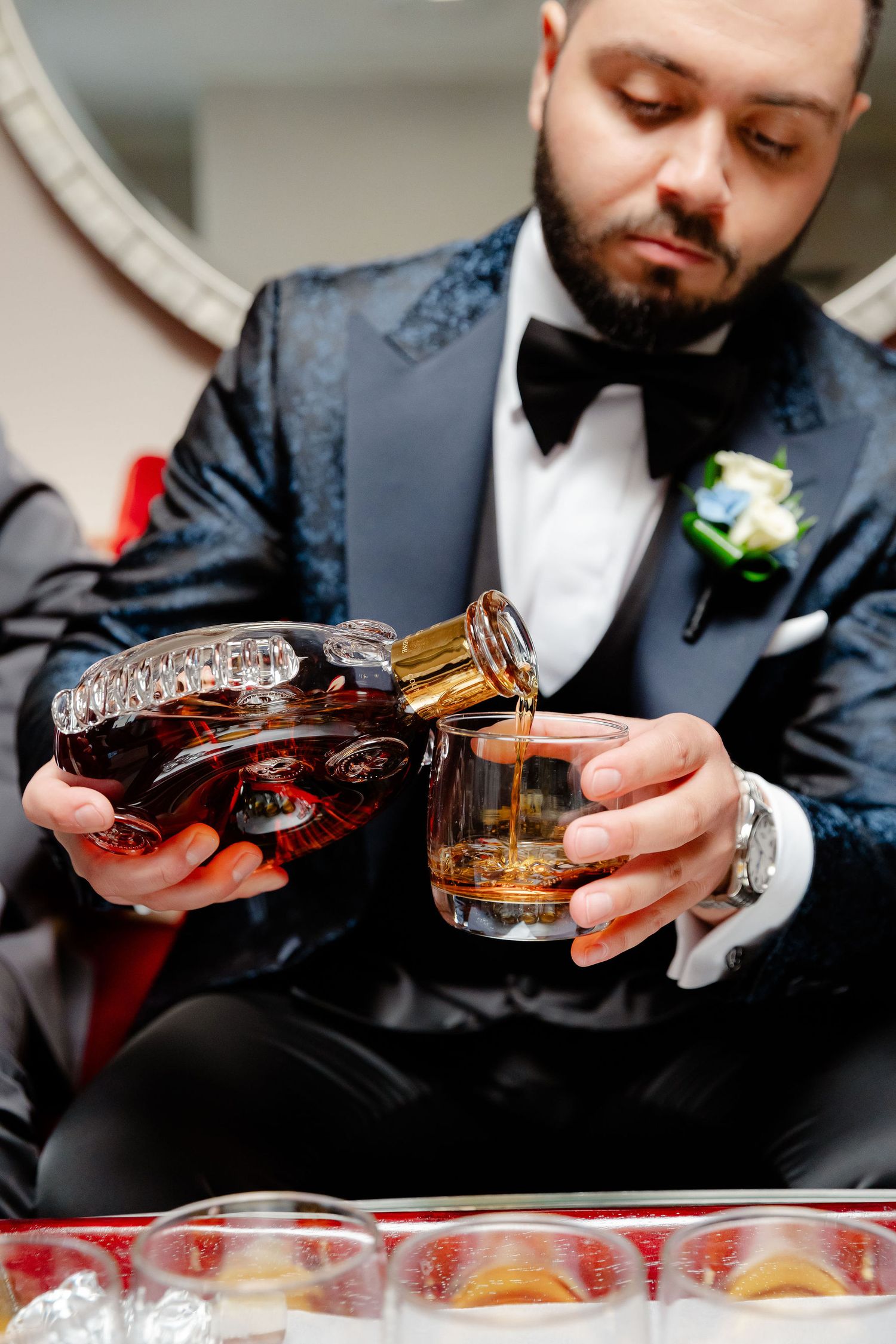 Pouring premium cognac into crystal glasses at formal event.