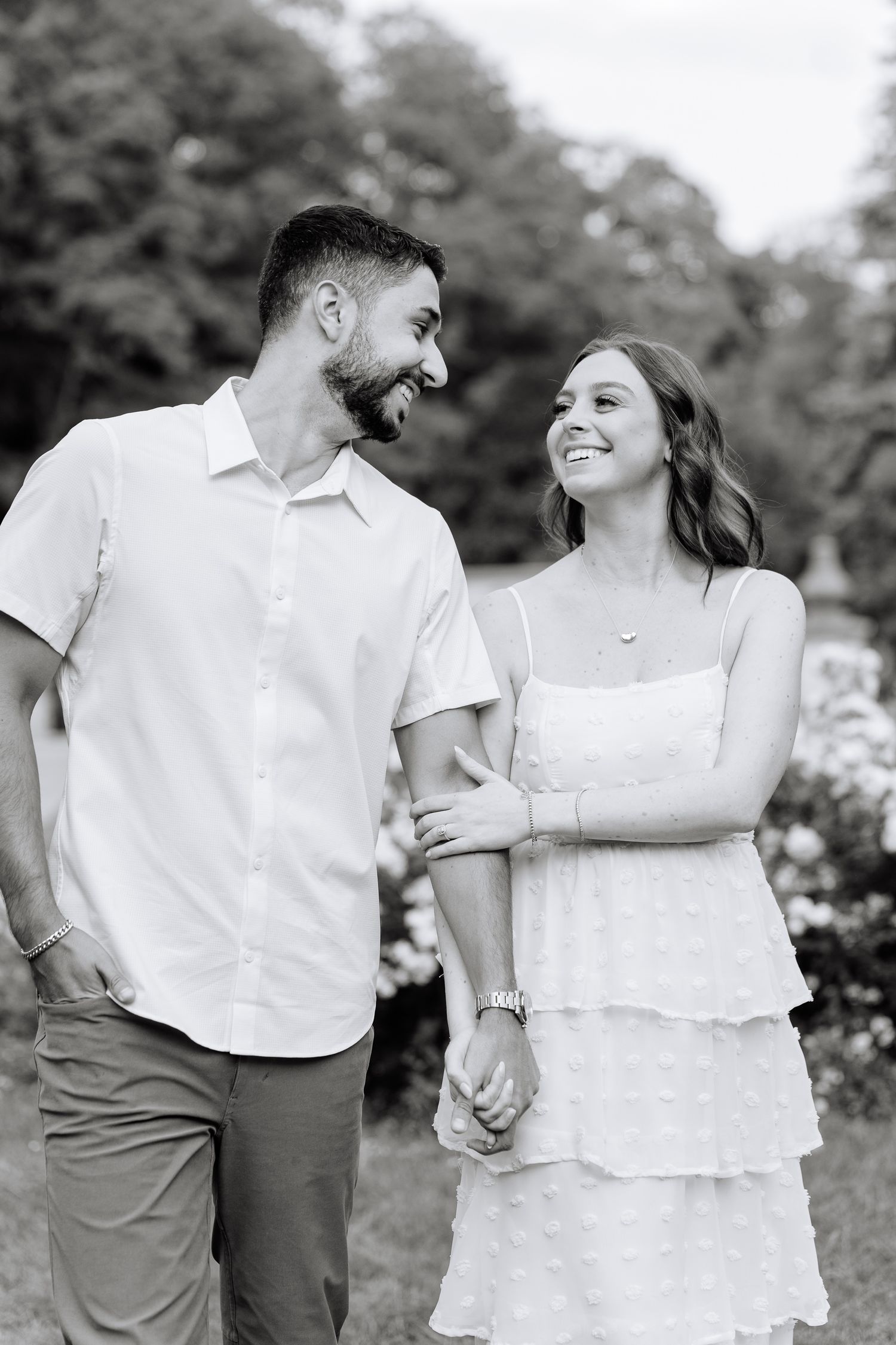 A black and white portrait showing a joyful moment in a garden setting.