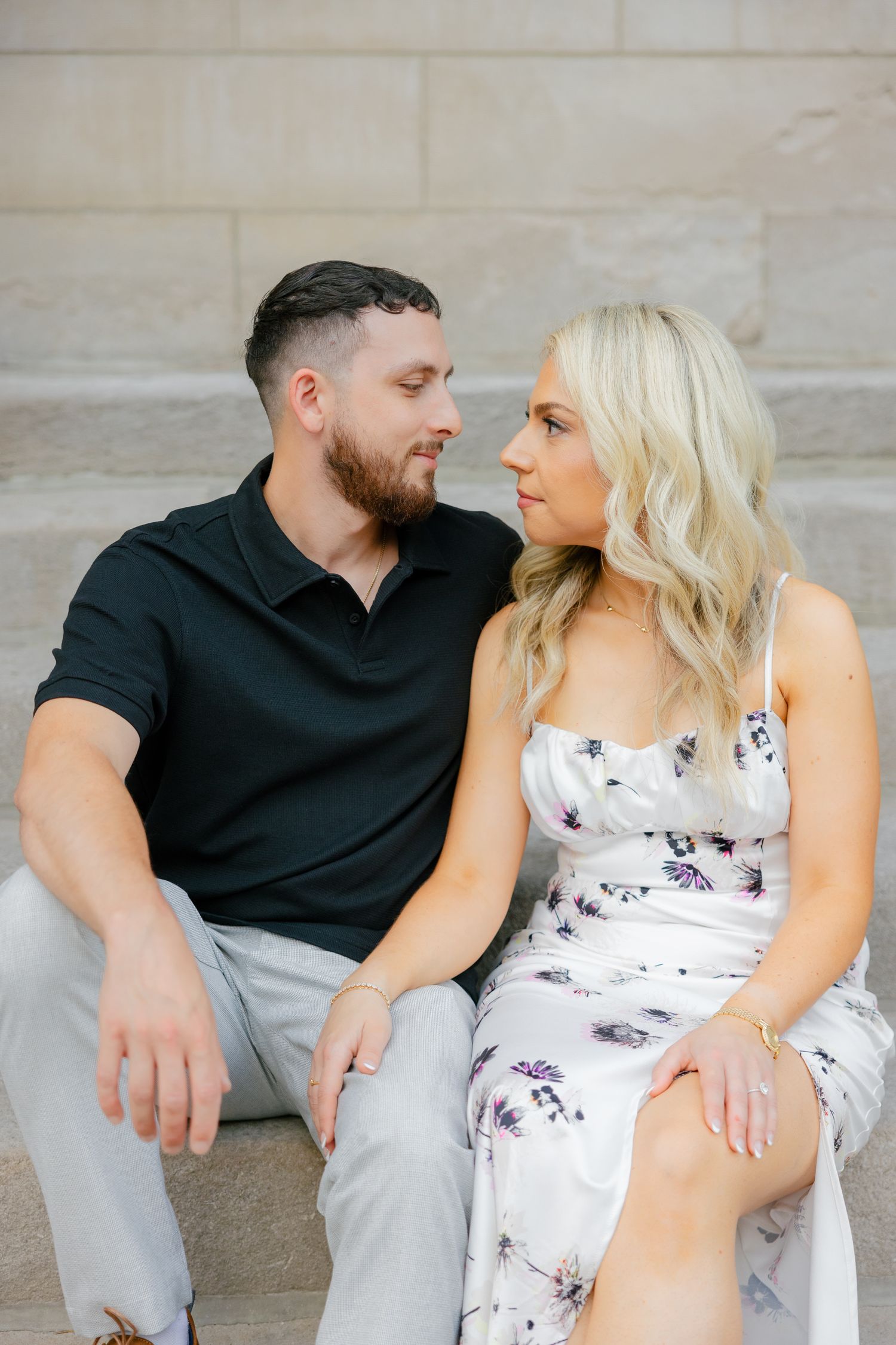 A sweet candid moment between a couple sitting on architectural steps.