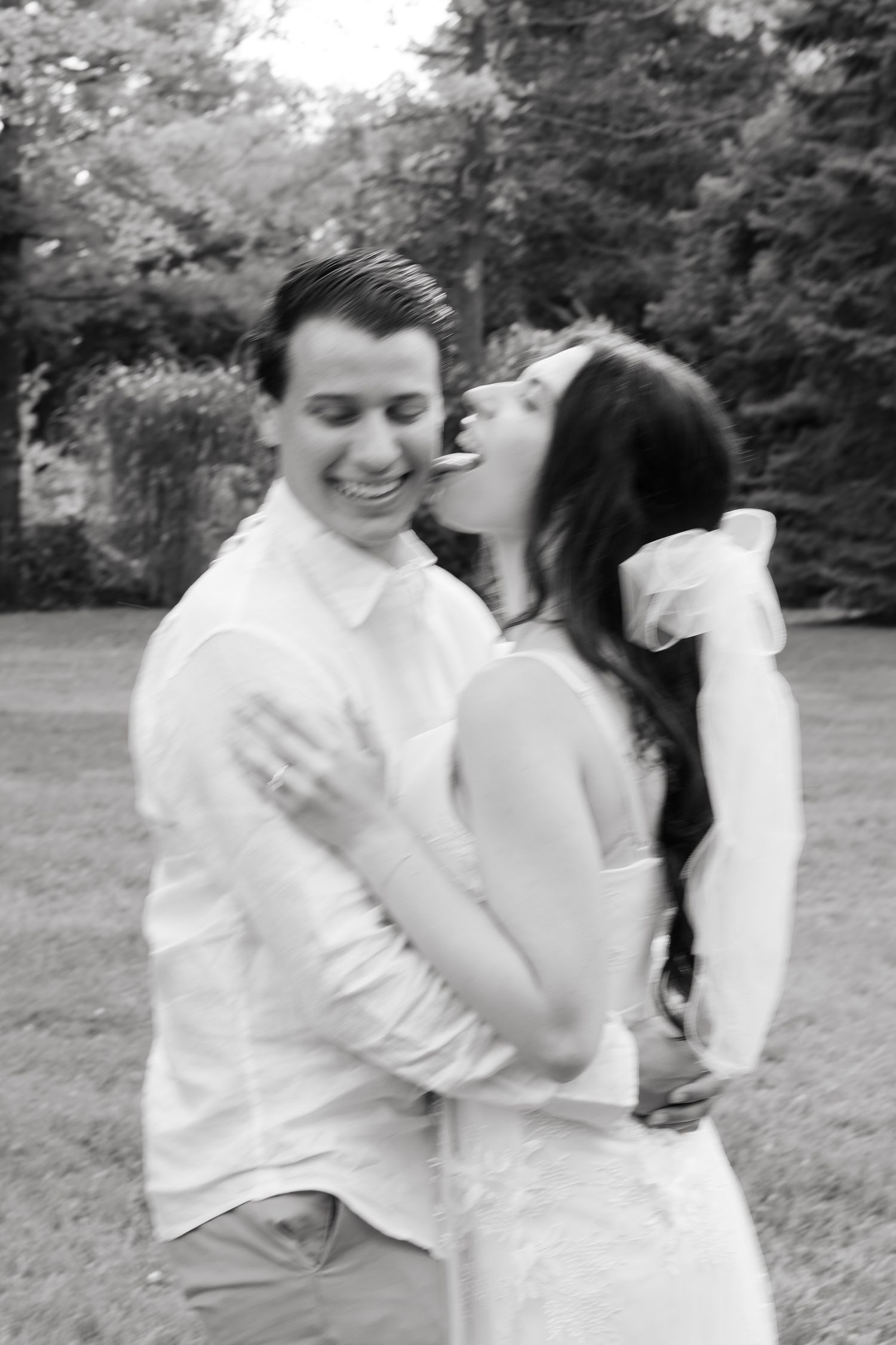 A black and white capture of a tender wedding moment in a garden setting.