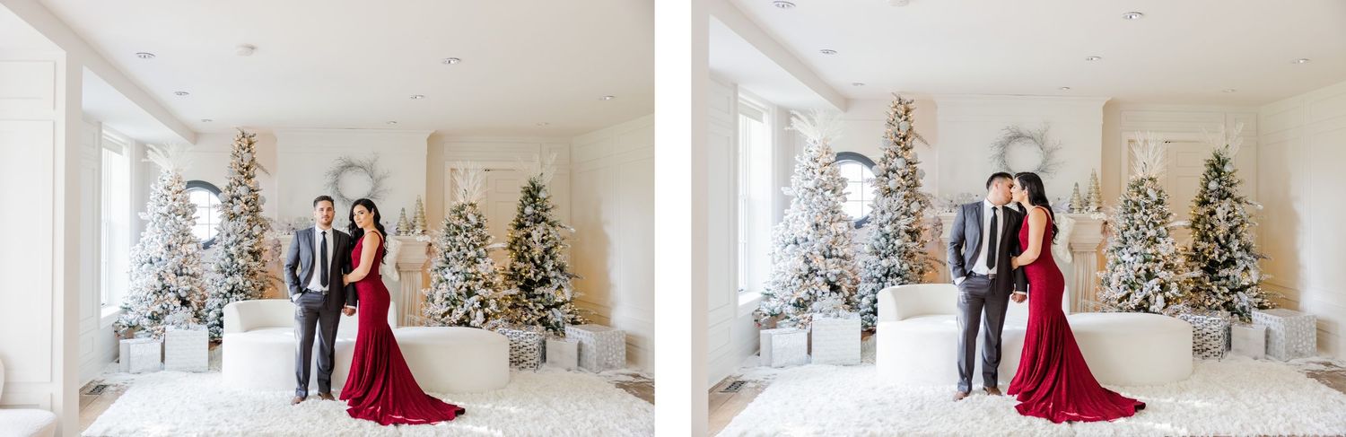 Holiday portrait showing a couple standing against festive flocked Christmas trees in an elegant white room.