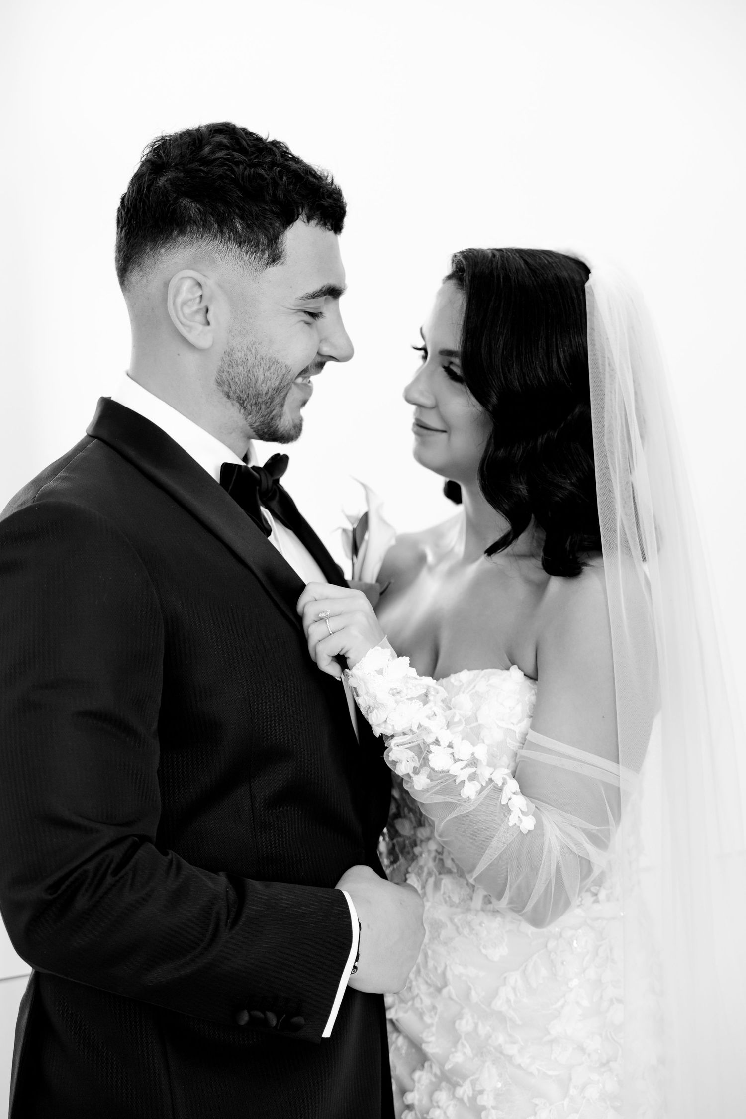 An intimate black and white portrait of newlyweds sharing a joyful moment together.