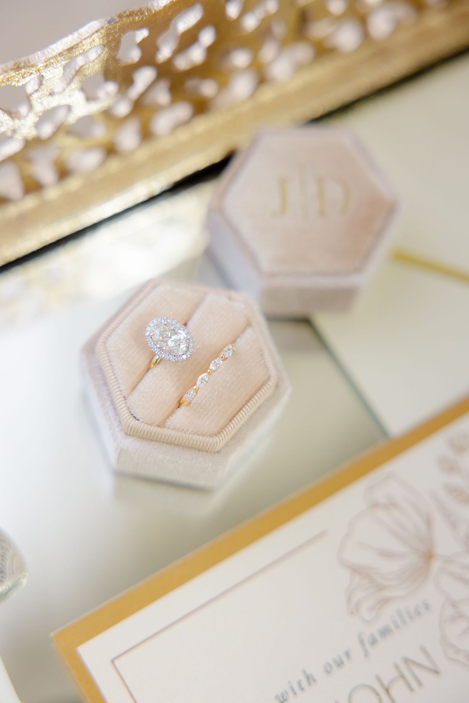 Diamond engagement ring in hexagonal blush velvet ring box with gold accents.