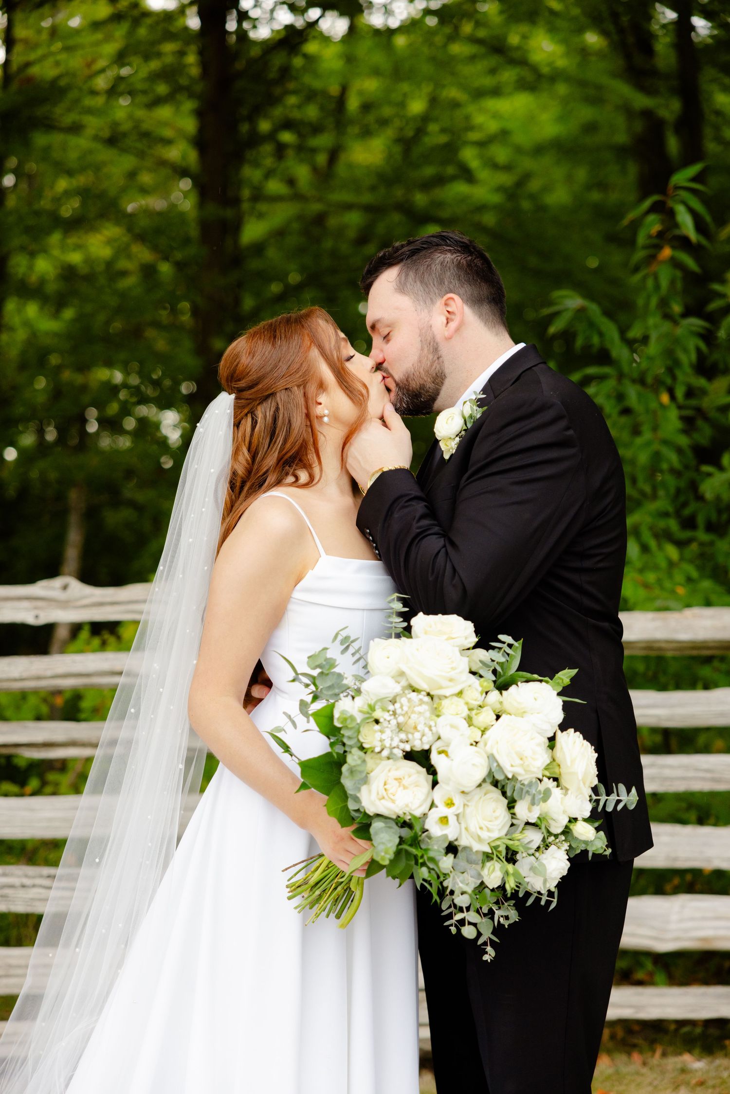 Romantic wedding portrait showing an intimate moment between newlyweds in a woodland setting.