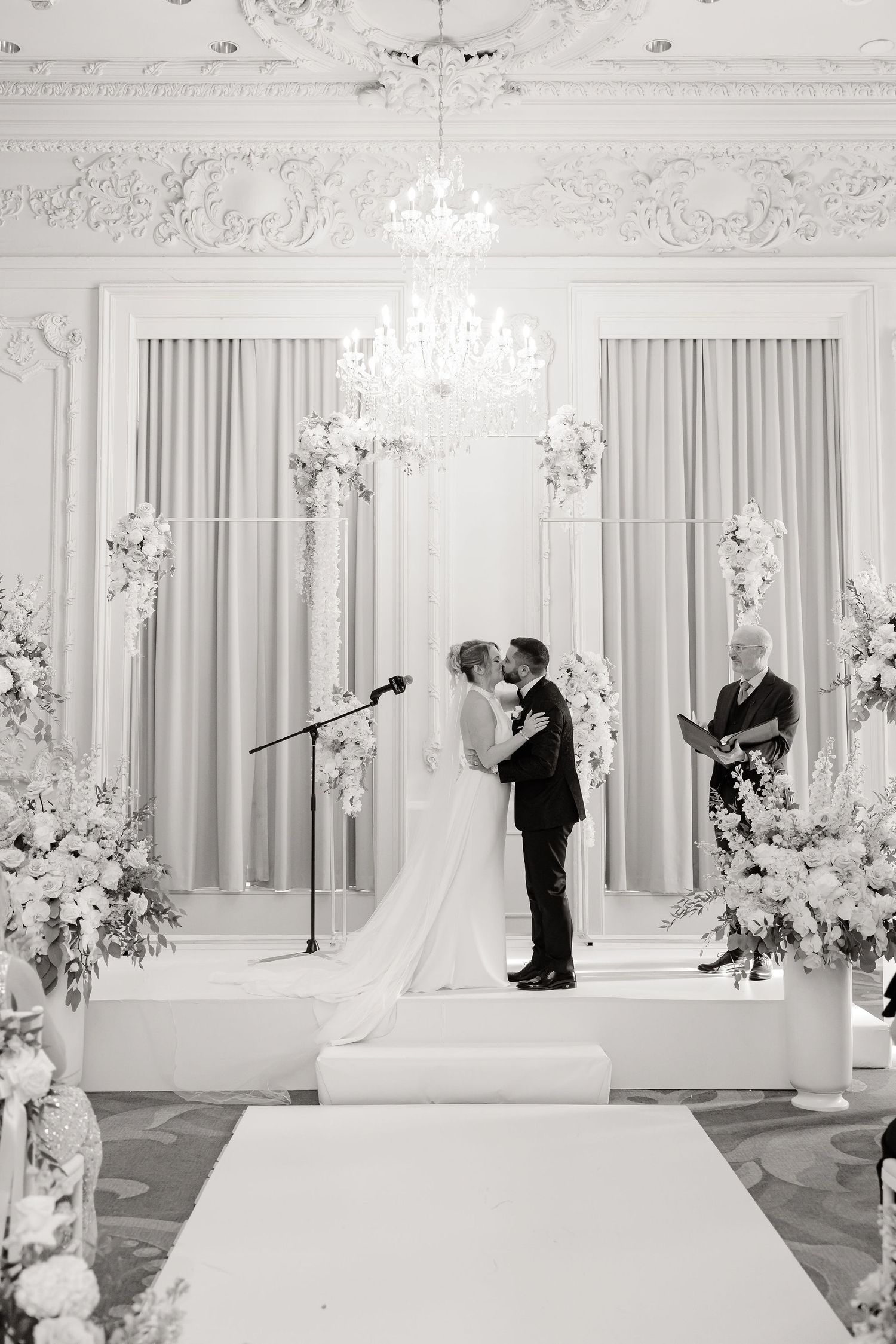 Black and white wedding ceremony photos in luxurious ballroom setting.