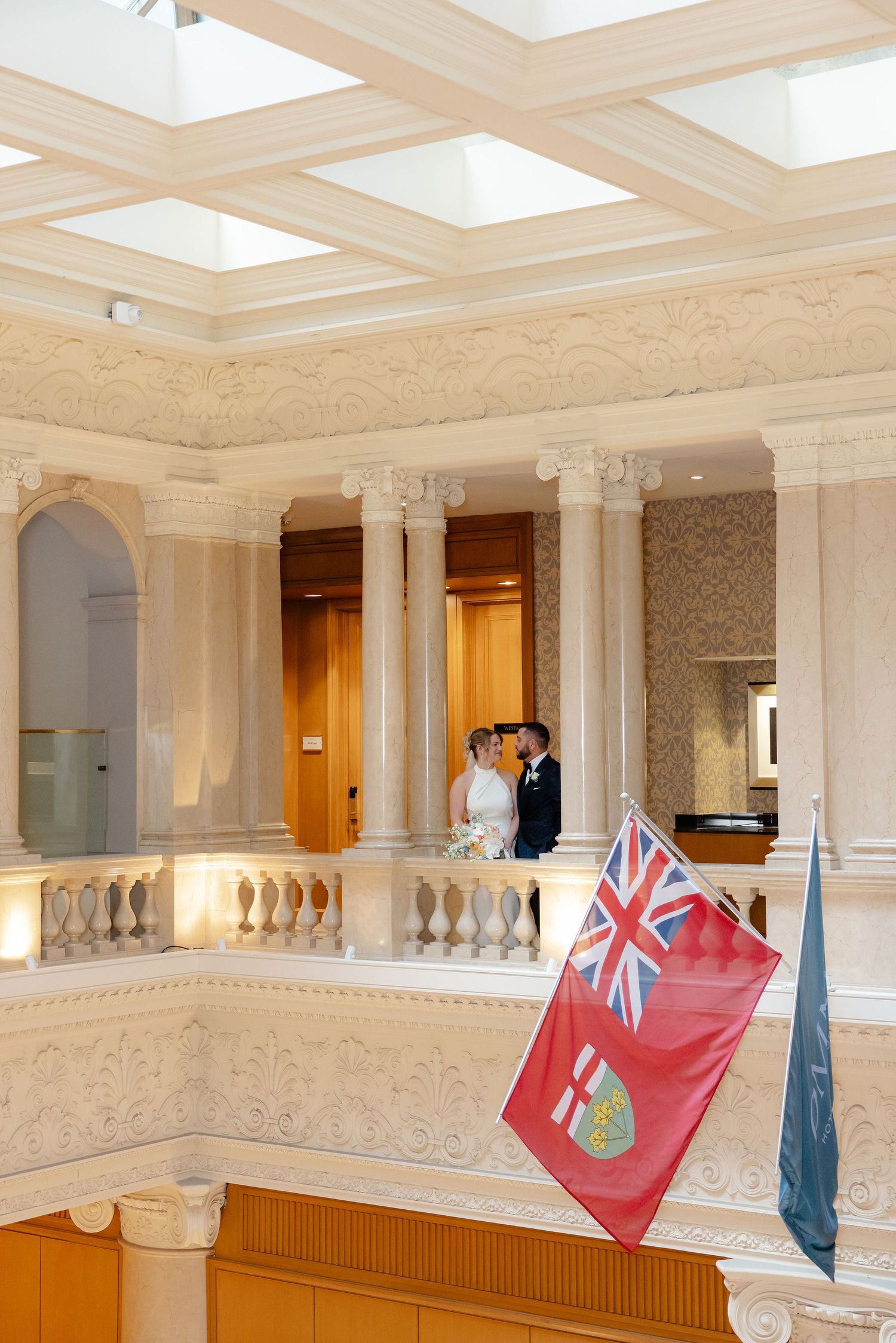 Elegant wedding venue interior with British flags and ornate white columns and balconies.