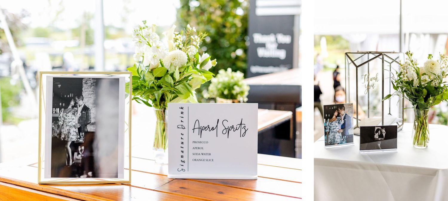 Wedding guest book display with white floral arrangements and framed photos.