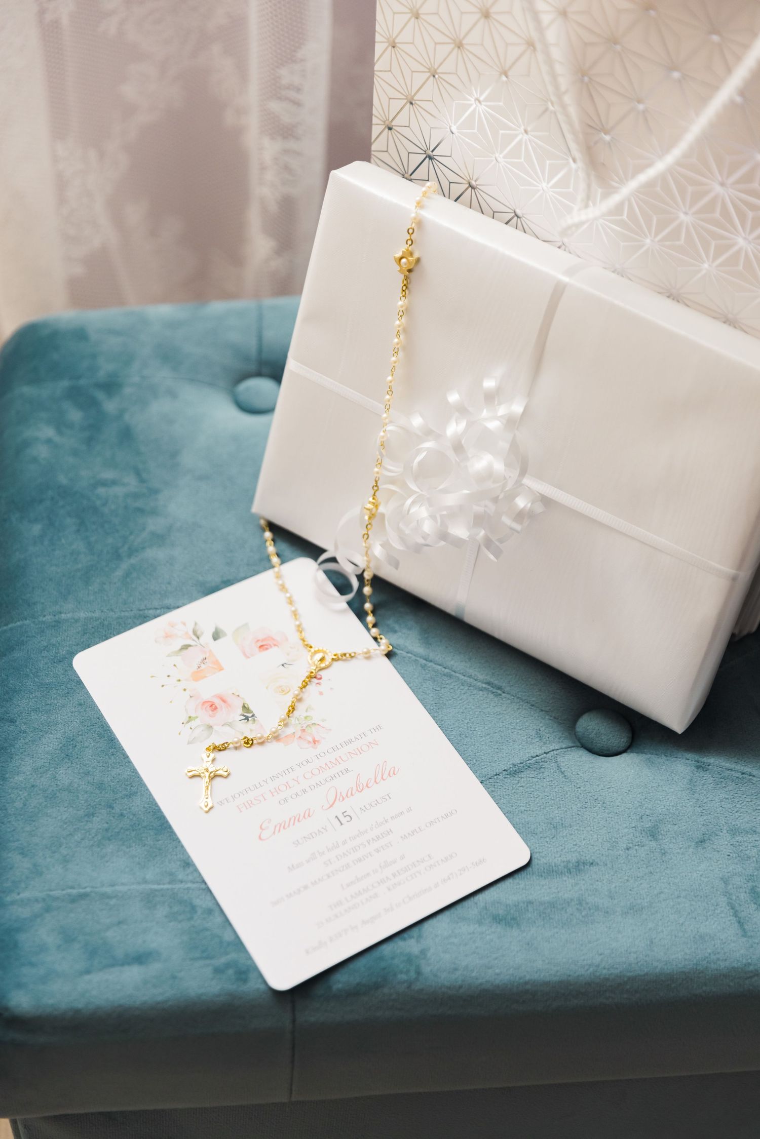 White wedding invitation and accessories displayed on turquoise velvet surface.