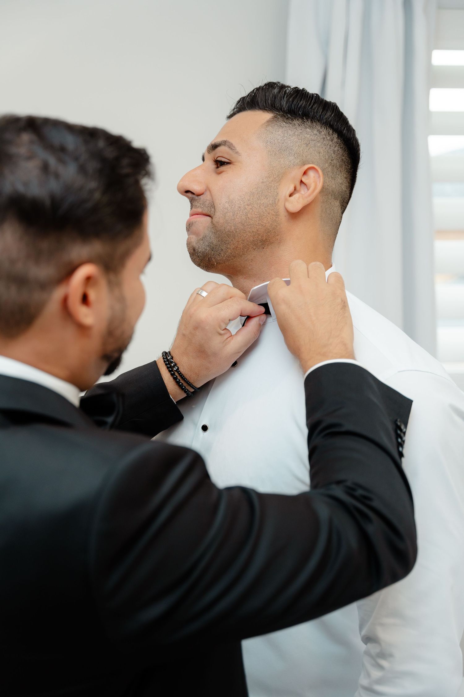 Final adjustments being made to formal white shirt collar.