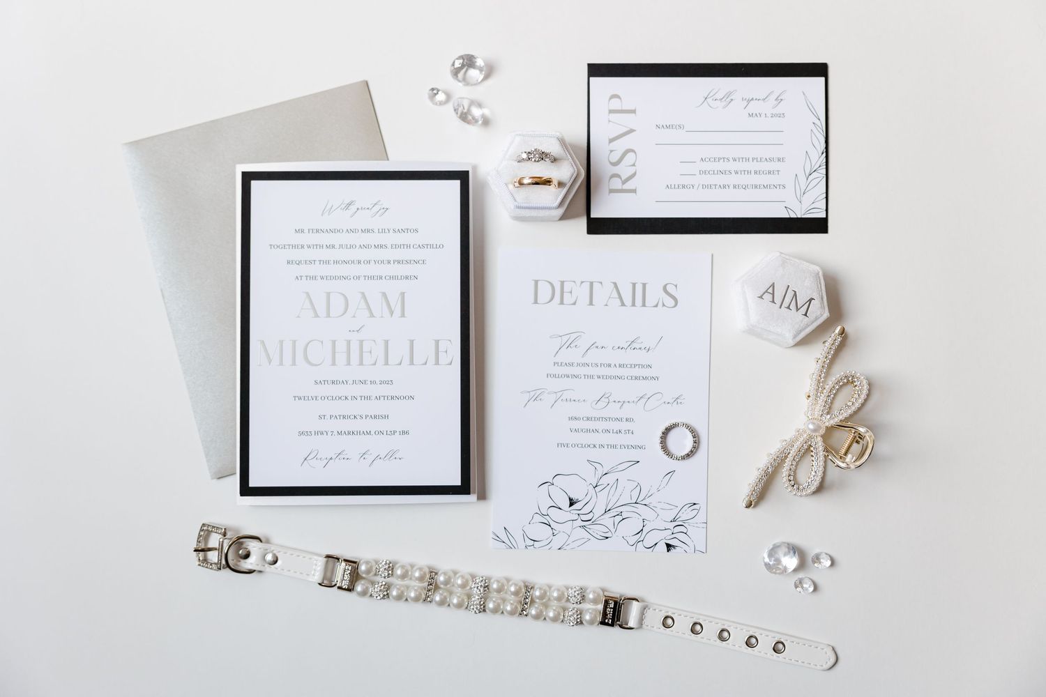 Wedding invitation suite with elegant monochrome design and jewelry accents.