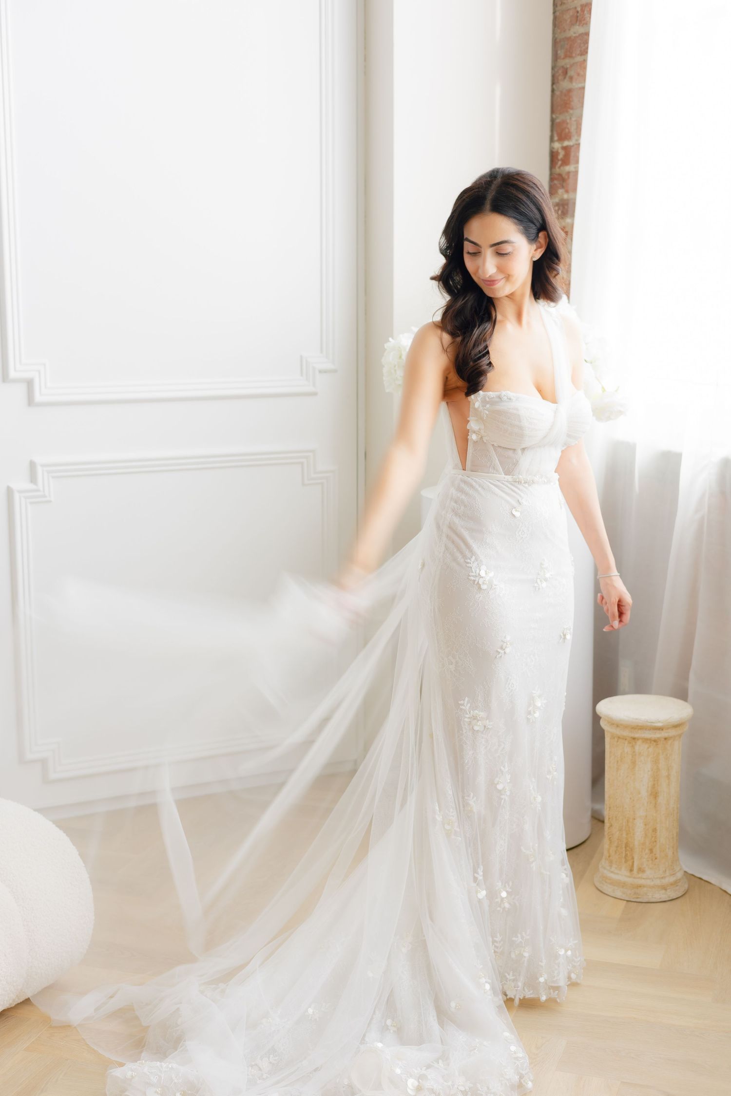 Stunning fitted lace wedding gown with flowing train photographed in natural light.