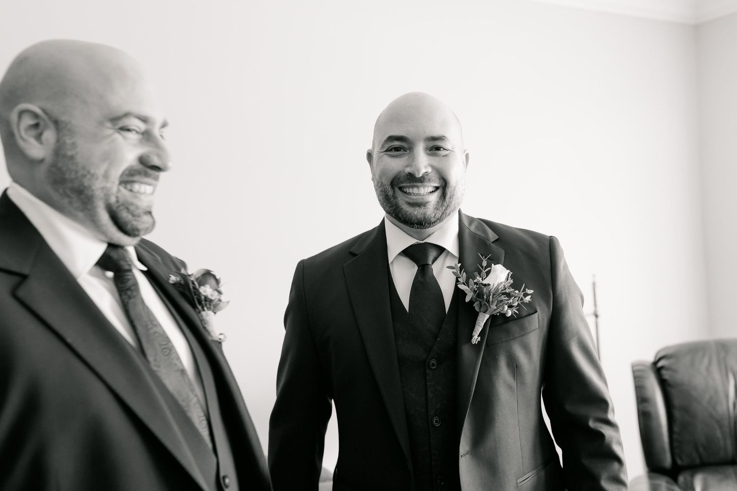 A black and white portrait of two people sharing a genuine laugh together.