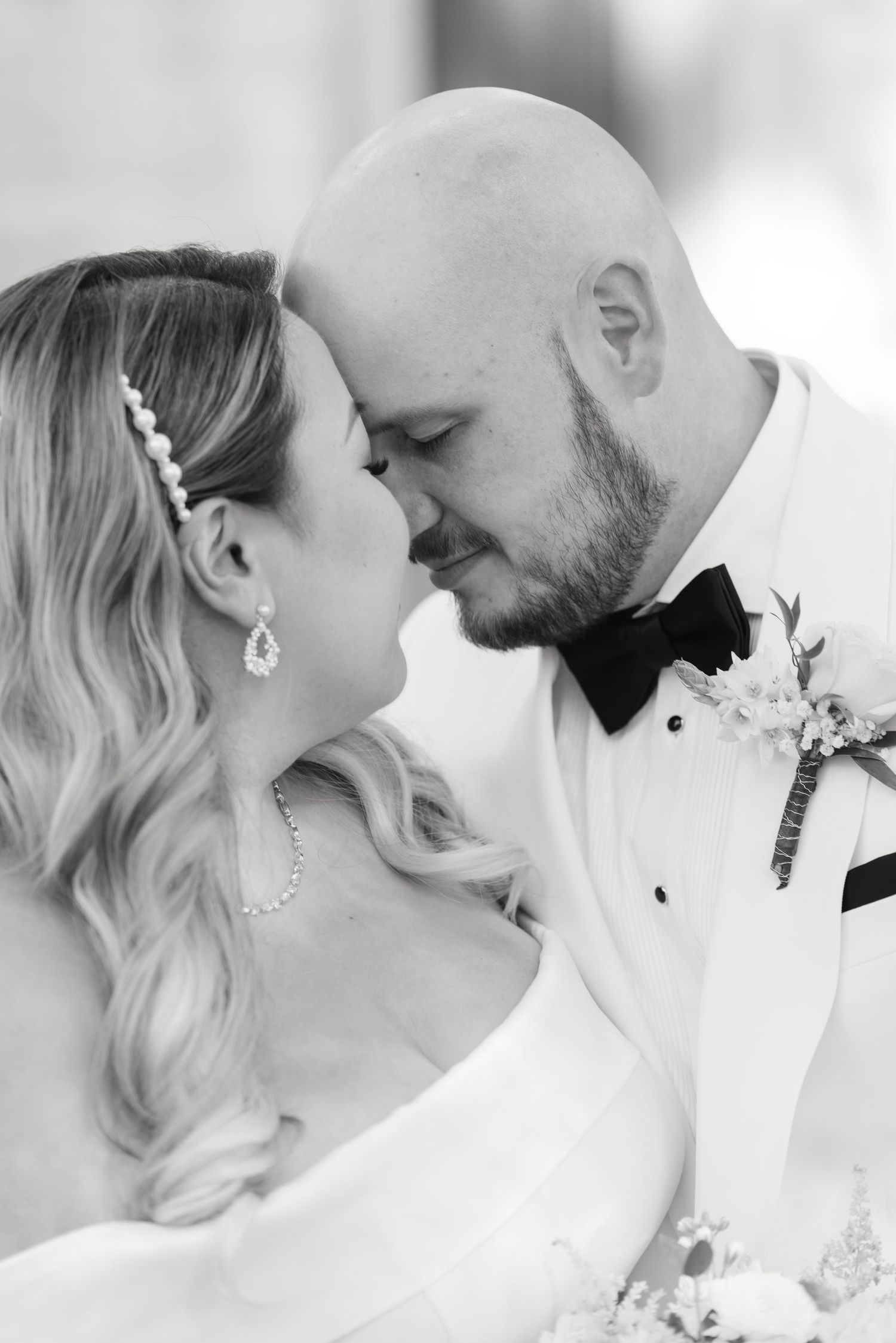 Intimate black and white portrait of newlyweds sharing romantic moment.