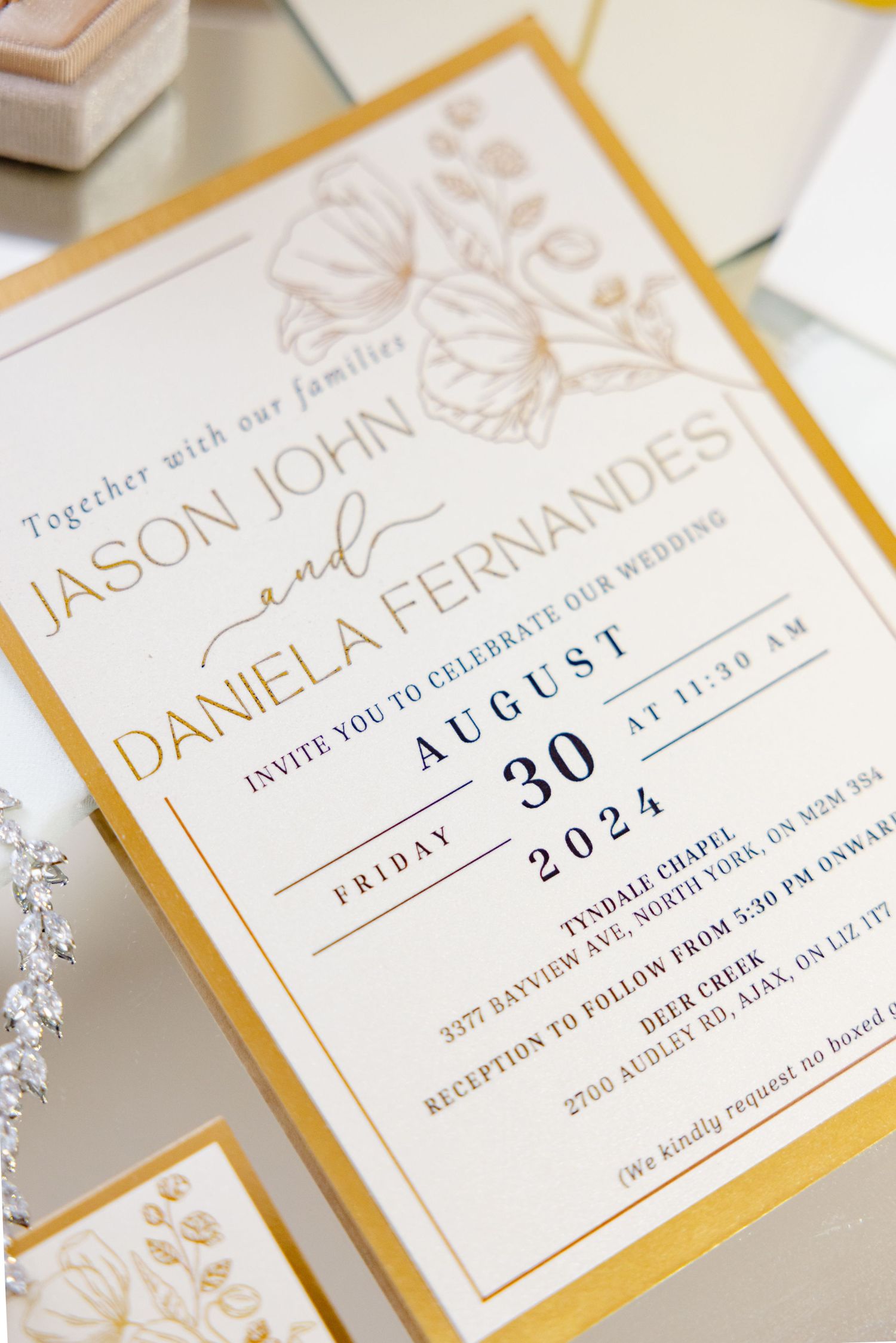 Elegant wedding invitation with gold borders and floral motifs in classic typography.