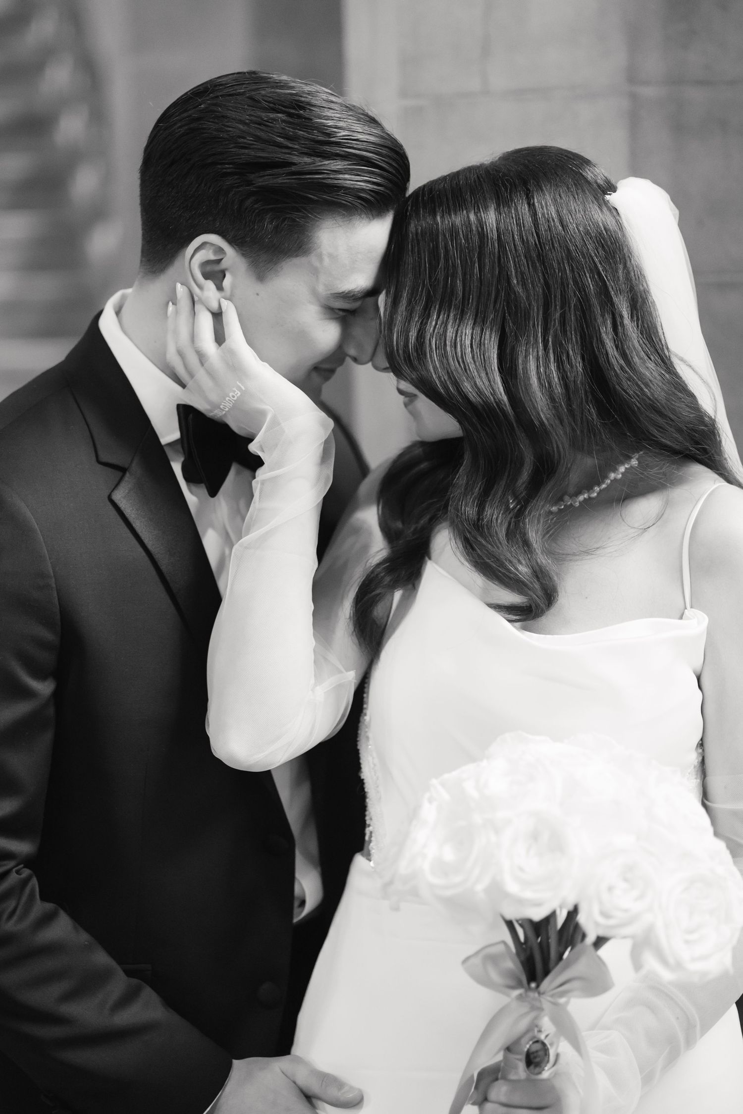 Black and white intimate portrait of newlyweds in tender embrace.