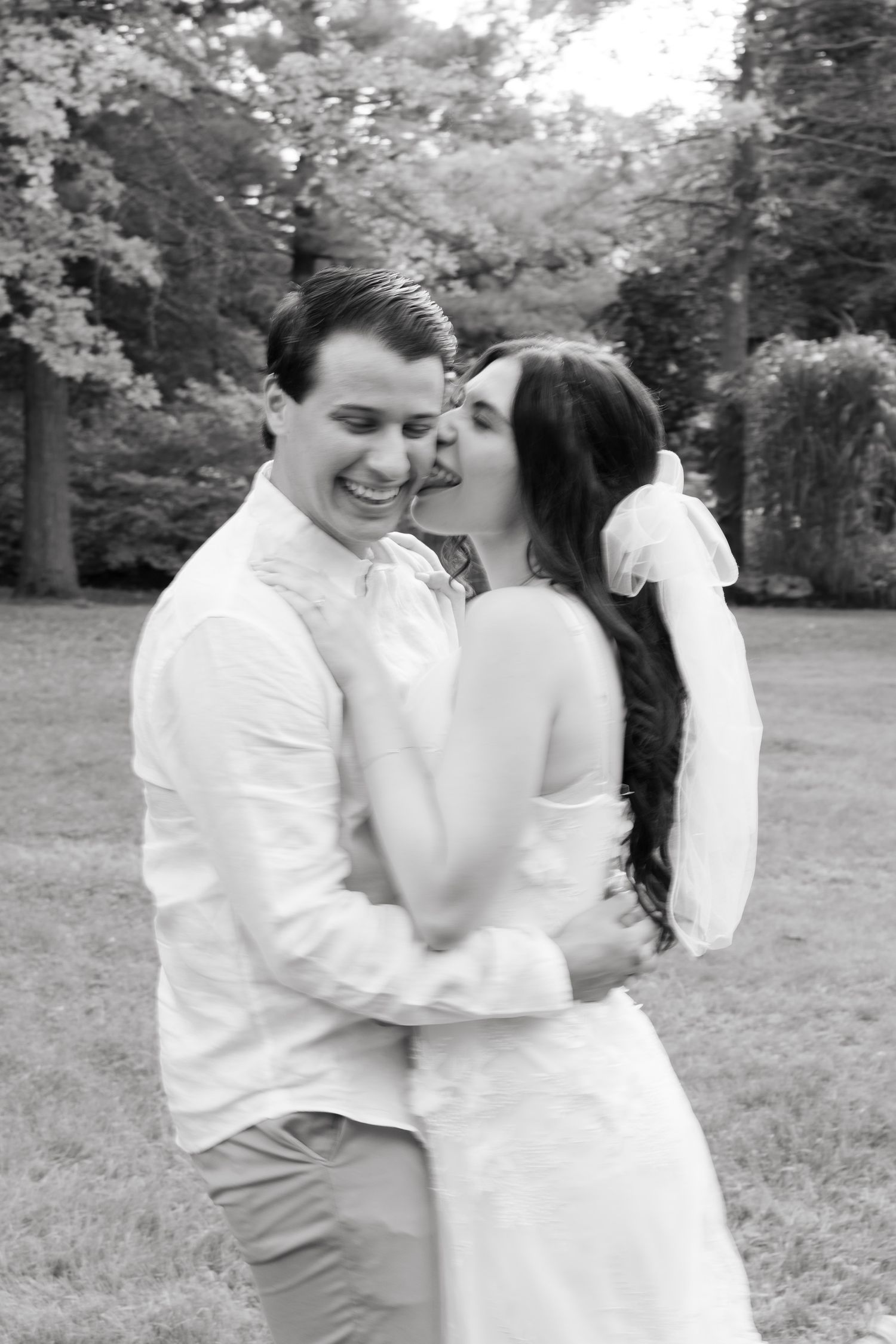 An intimate black and white portrait of newlyweds sharing a loving moment.