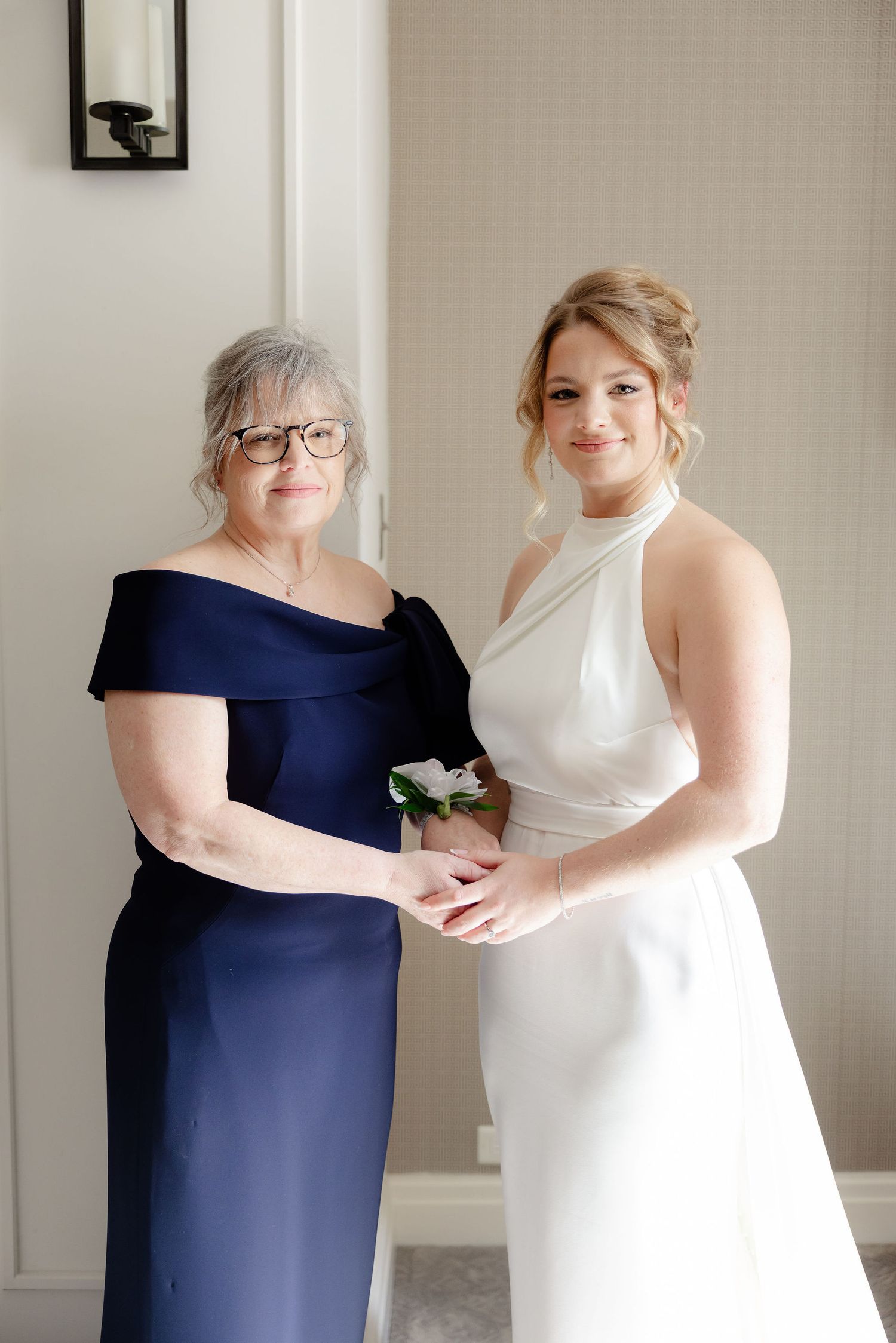 A series of four photos showing two people in navy blue and white formal dresses embracing during a special occasion.