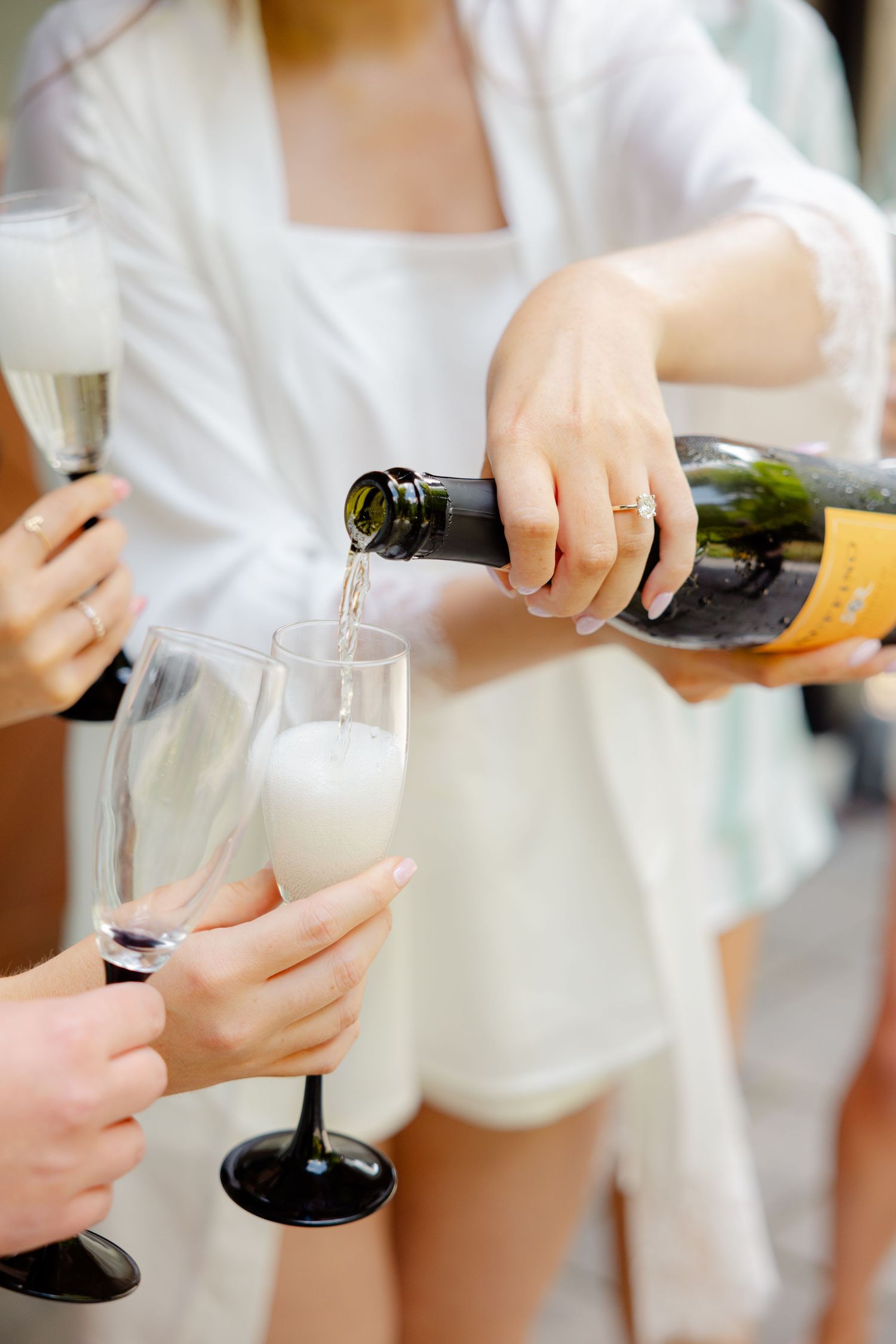 Champagne being poured into glasses during wedding morning preparations.