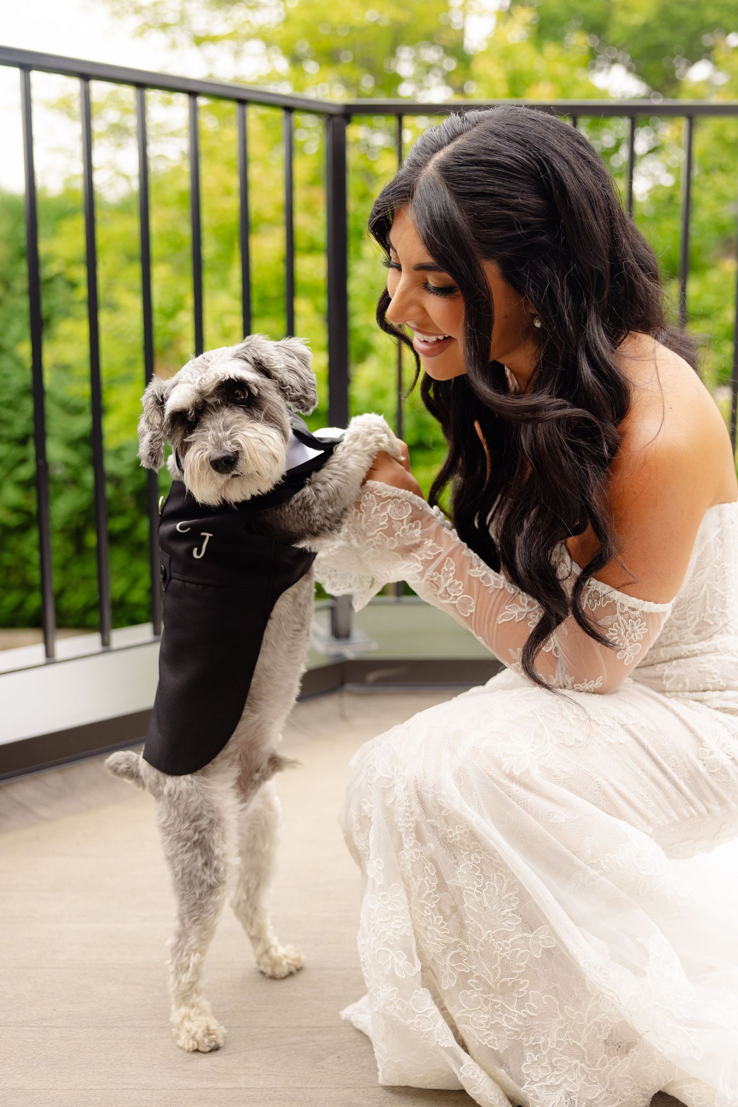A dog and someone wearing a white wedding dress pose together on a balcony in a series of sweet interaction photos.