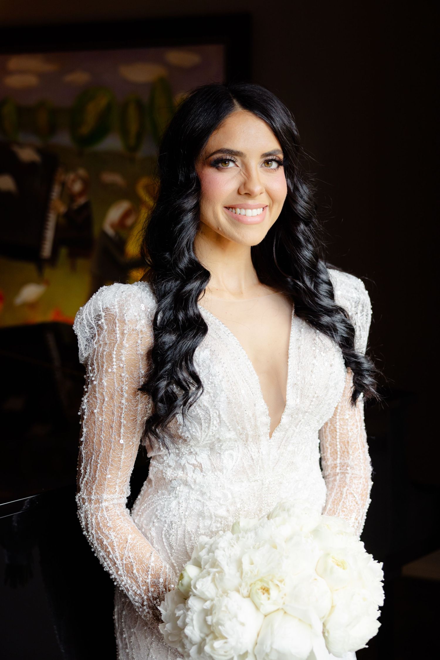 Radiant bridal portrait featuring long-sleeved beaded gown and classic white bouquet.