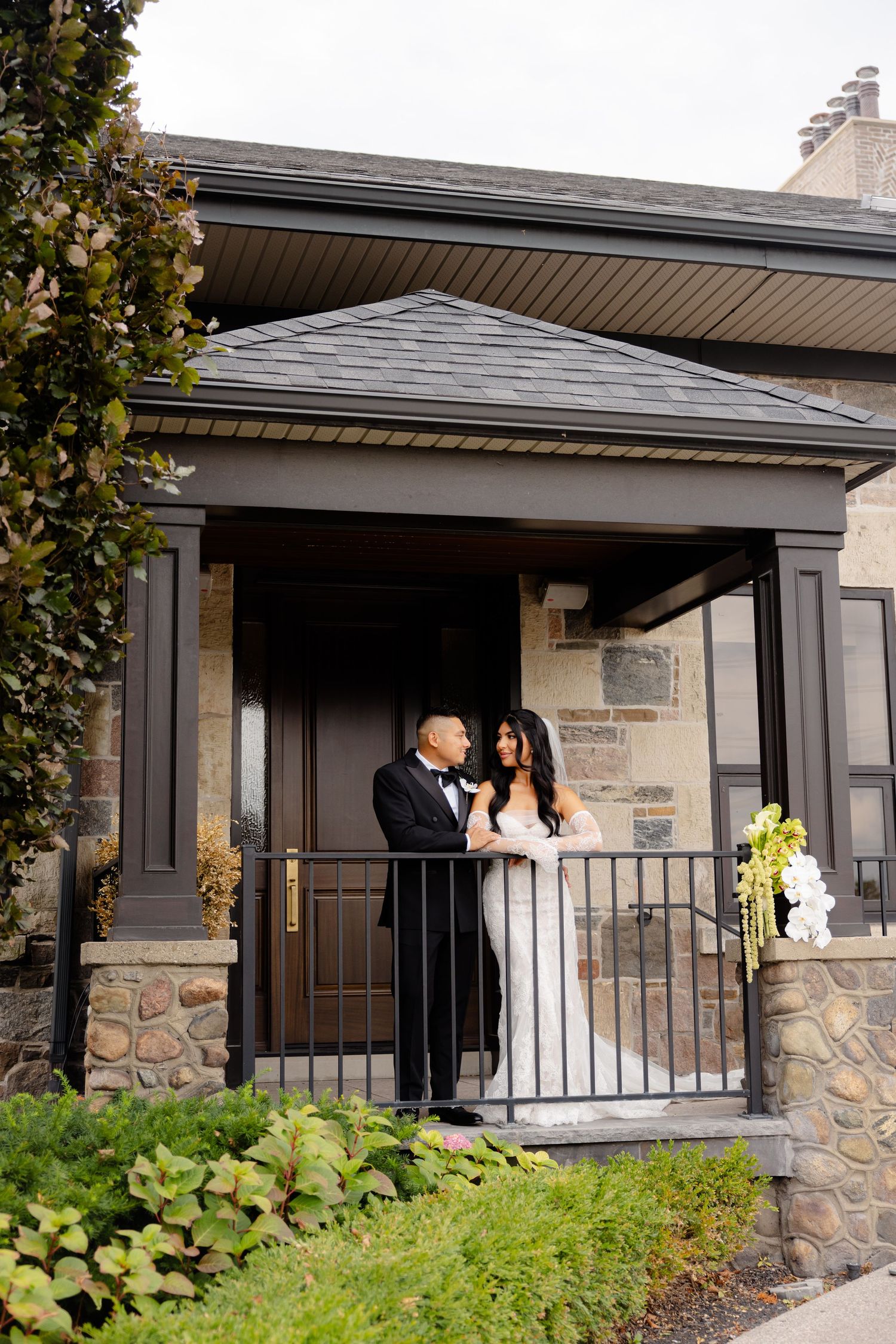 A romantic wedding portrait sequence showing multiple different poses of a couple at a modern stone building entrance.